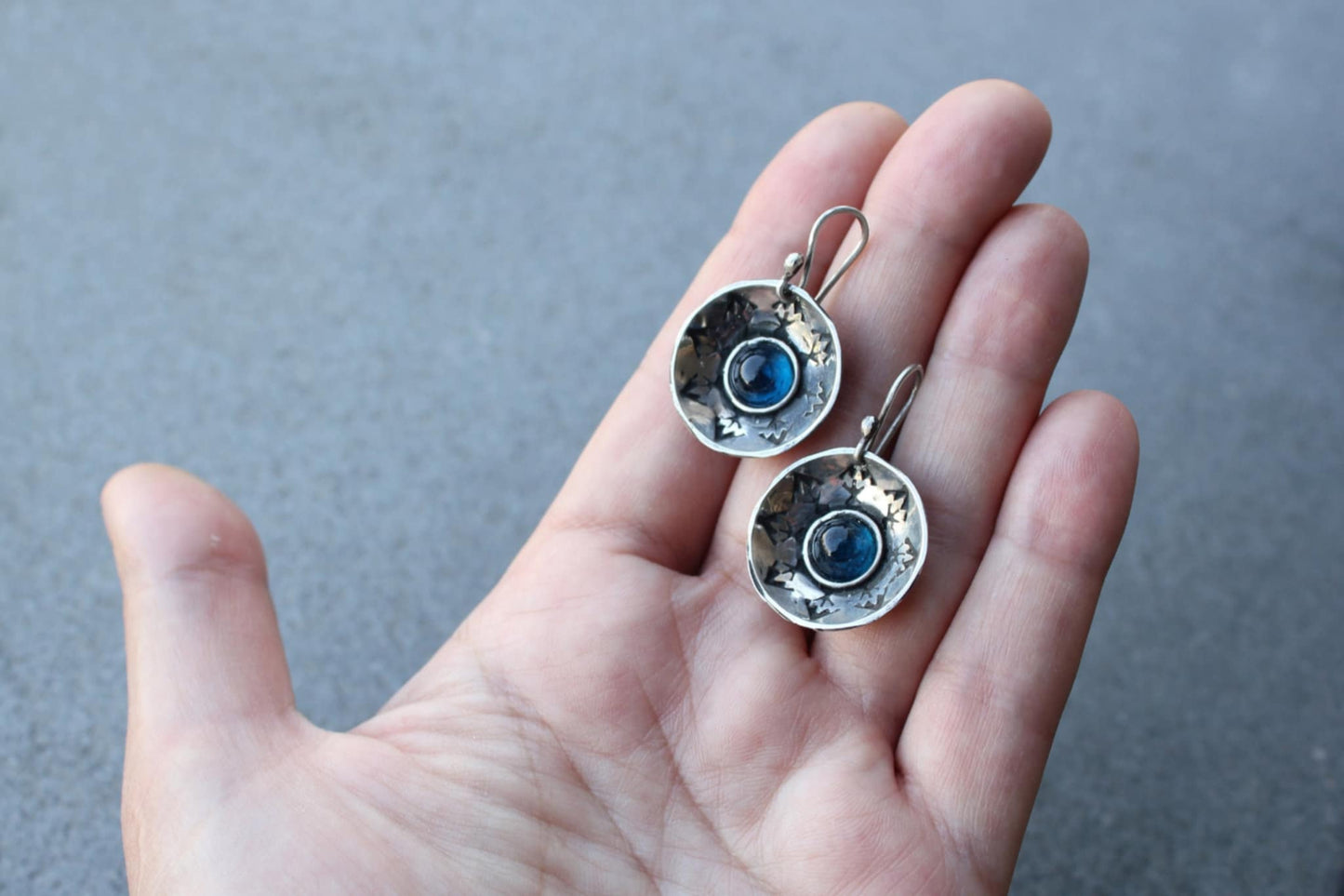 Handcrafted artisan Armenian silversmith sterling silver concave disc earrings featuring a central blue corundum cabochon, accented by stamped geometric patterns