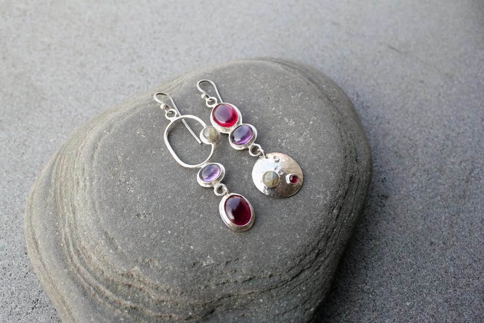 Mismatched sterling silver silversmith Armenian artisan handmade drop earrings, featuring oval red and purple corundums and labradorite stones