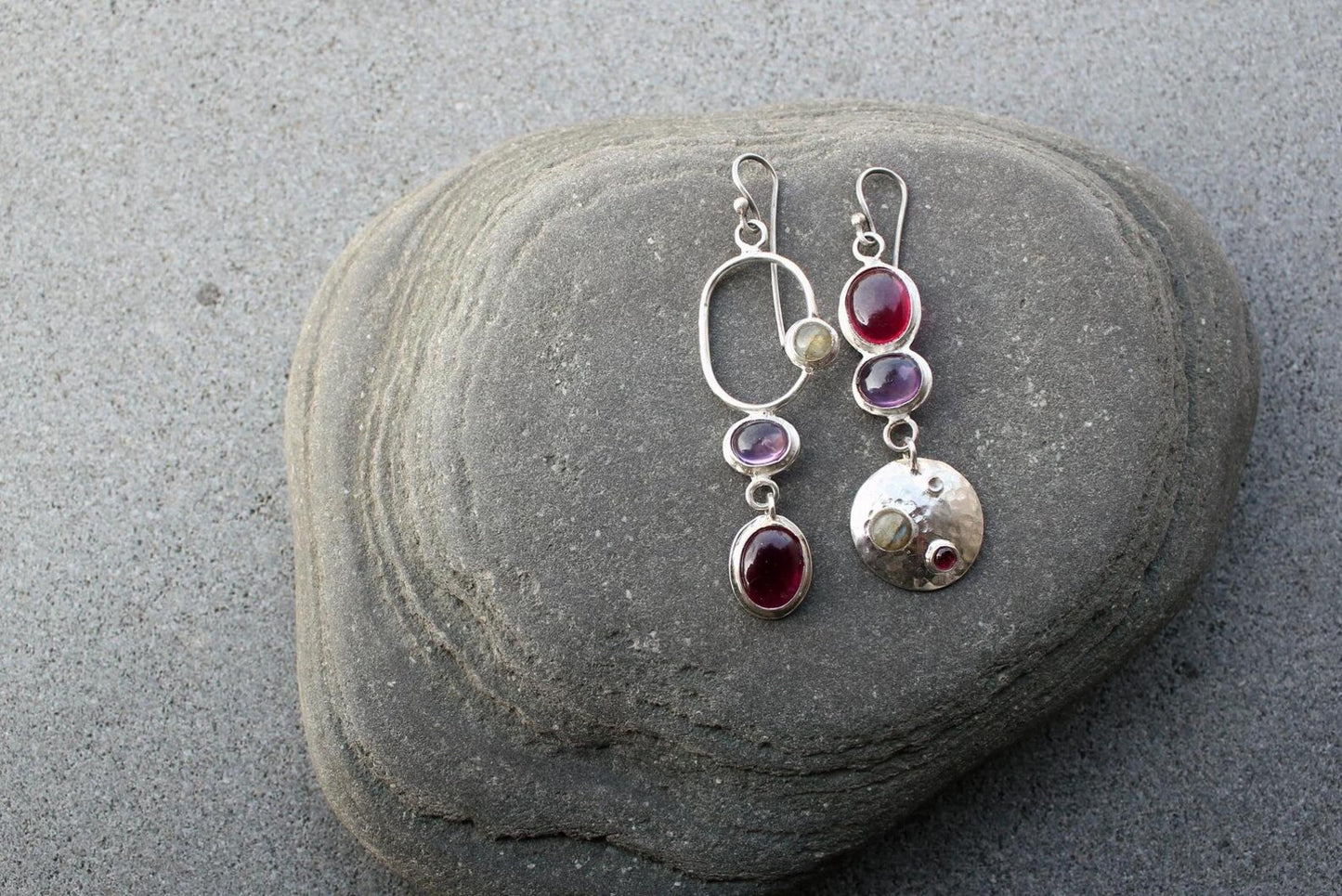 Mismatched sterling silver silversmith Armenian artisan handmade drop earrings, featuring oval red and purple corundums and labradorite stones