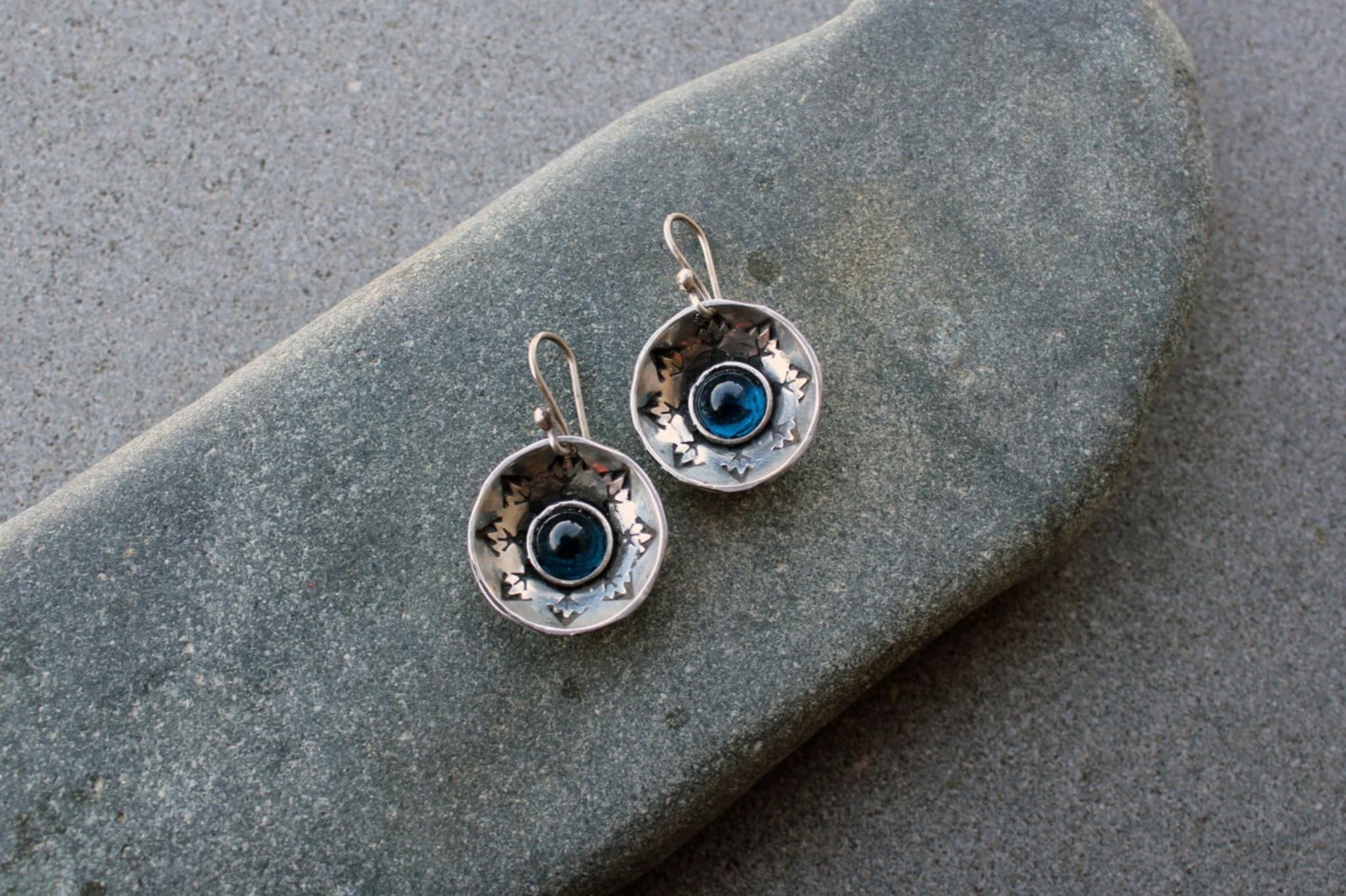 Handcrafted artisan Armenian silversmith sterling silver concave disc earrings featuring a central blue corundum cabochon, accented by stamped geometric patterns