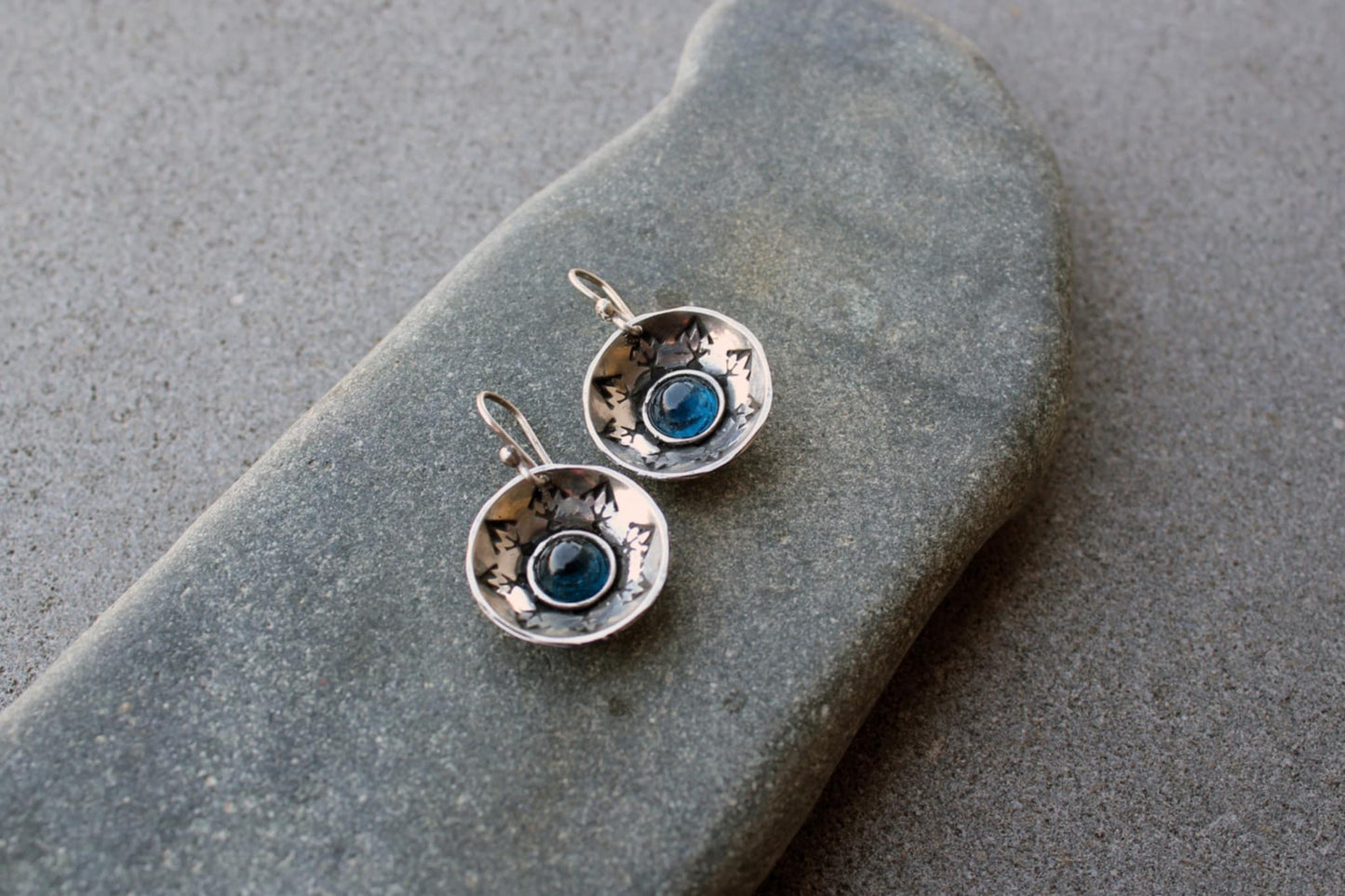 Handcrafted artisan Armenian silversmith sterling silver concave disc earrings featuring a central blue corundum cabochon, accented by stamped geometric patterns