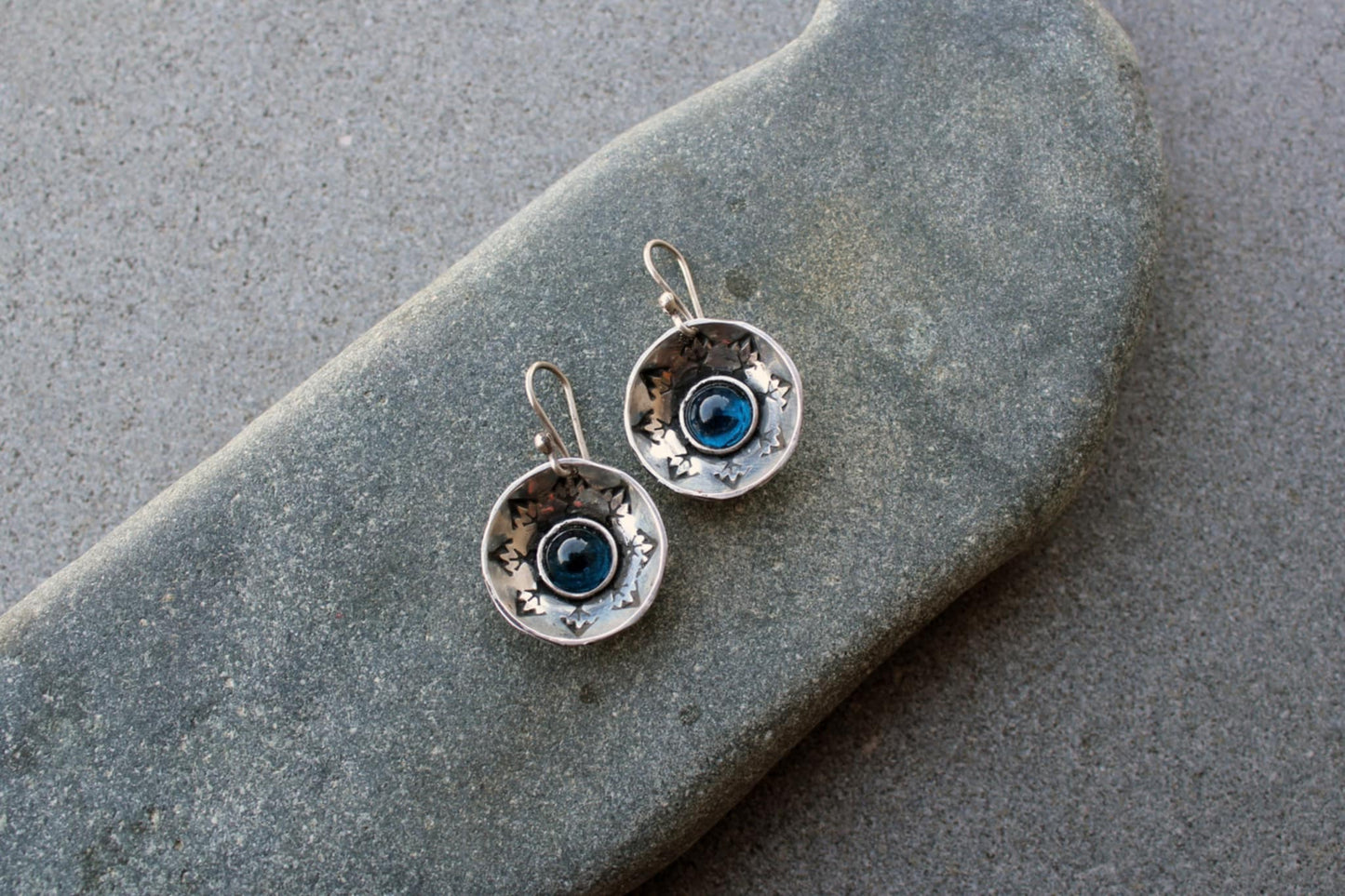 Handcrafted artisan Armenian silversmith sterling silver concave disc earrings featuring a central blue corundum cabochon, accented by stamped geometric patterns