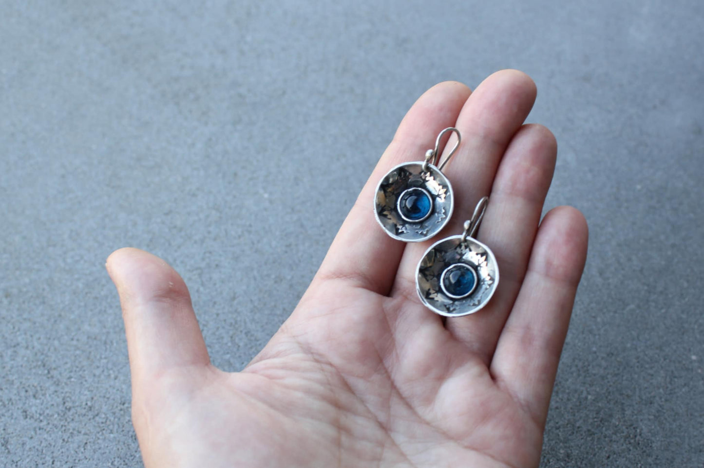 Handcrafted artisan Armenian silversmith sterling silver concave disc earrings featuring a central blue corundum cabochon, accented by stamped geometric patterns