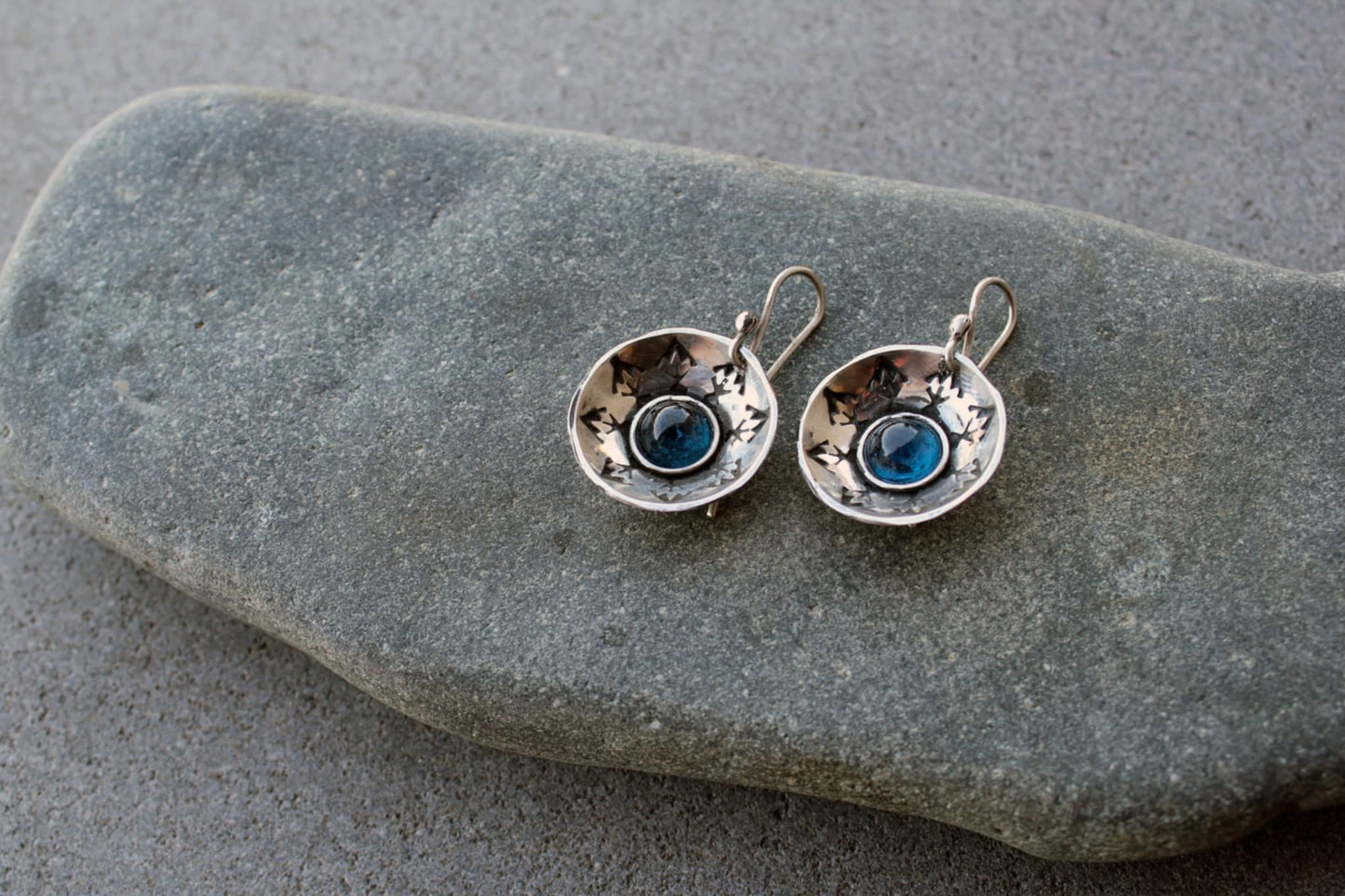Handcrafted artisan Armenian silversmith sterling silver concave disc earrings featuring a central blue corundum cabochon, accented by stamped geometric patterns