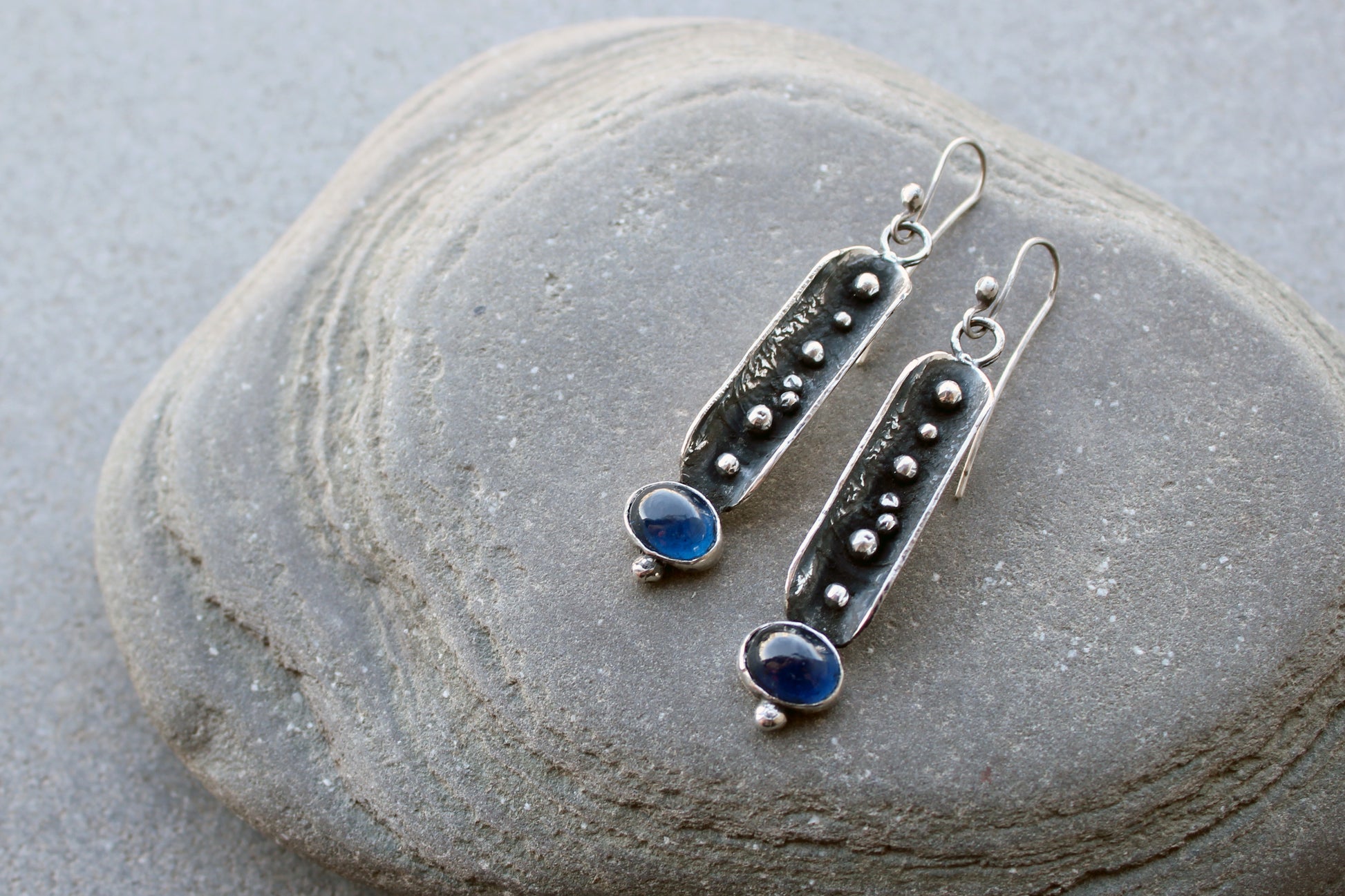 Handcrafted artisan Armenian reticulated sterling silver pod earrings featuring granulated textures and oval lab-grown blue corundum cabochons on classic ear wires