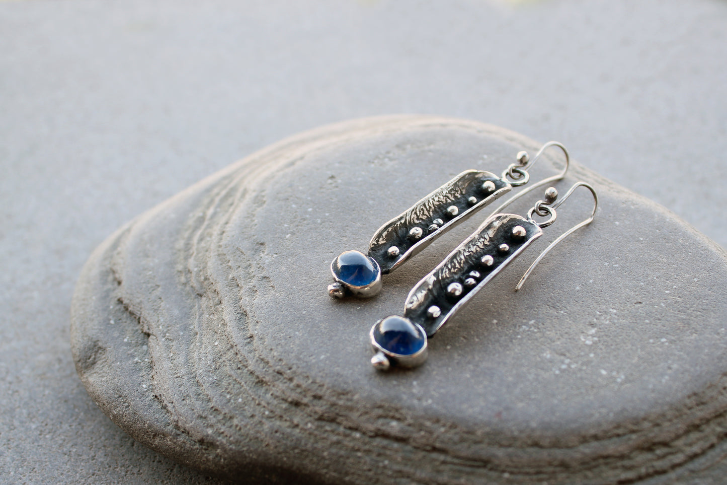 Handcrafted artisan Armenian reticulated sterling silver pod earrings featuring granulated textures and oval lab-grown blue corundum cabochons on classic ear wires
