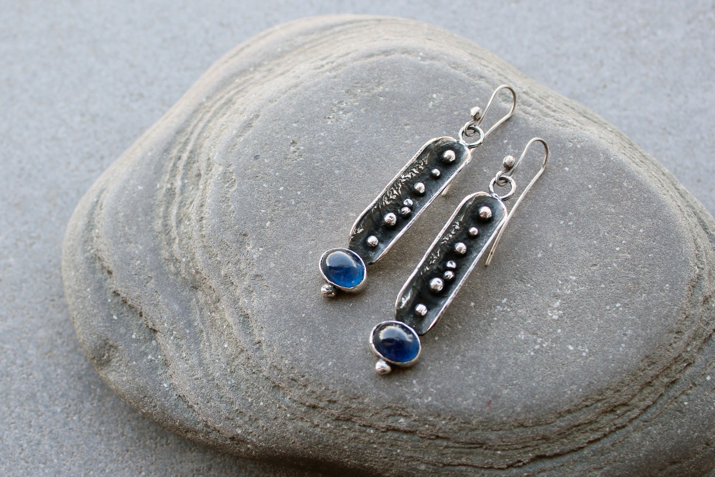 Handcrafted artisan Armenian reticulated sterling silver pod earrings featuring granulated textures and oval lab-grown blue corundum cabochons on classic ear wires