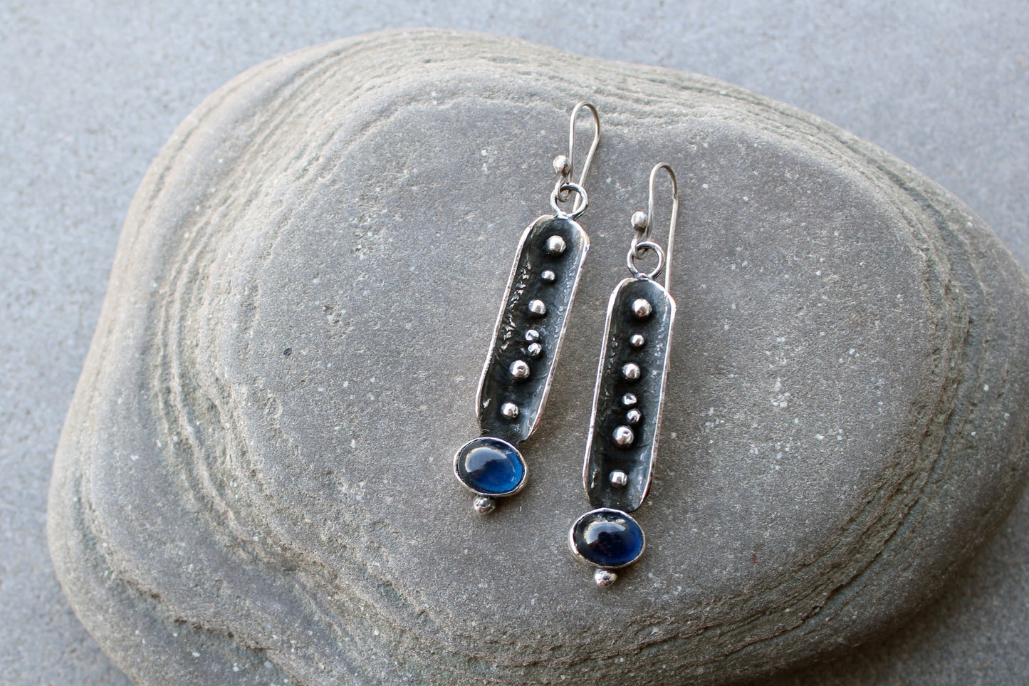 Handcrafted artisan Armenian reticulated sterling silver pod earrings featuring granulated textures and oval lab-grown blue corundum cabochons on classic ear wires