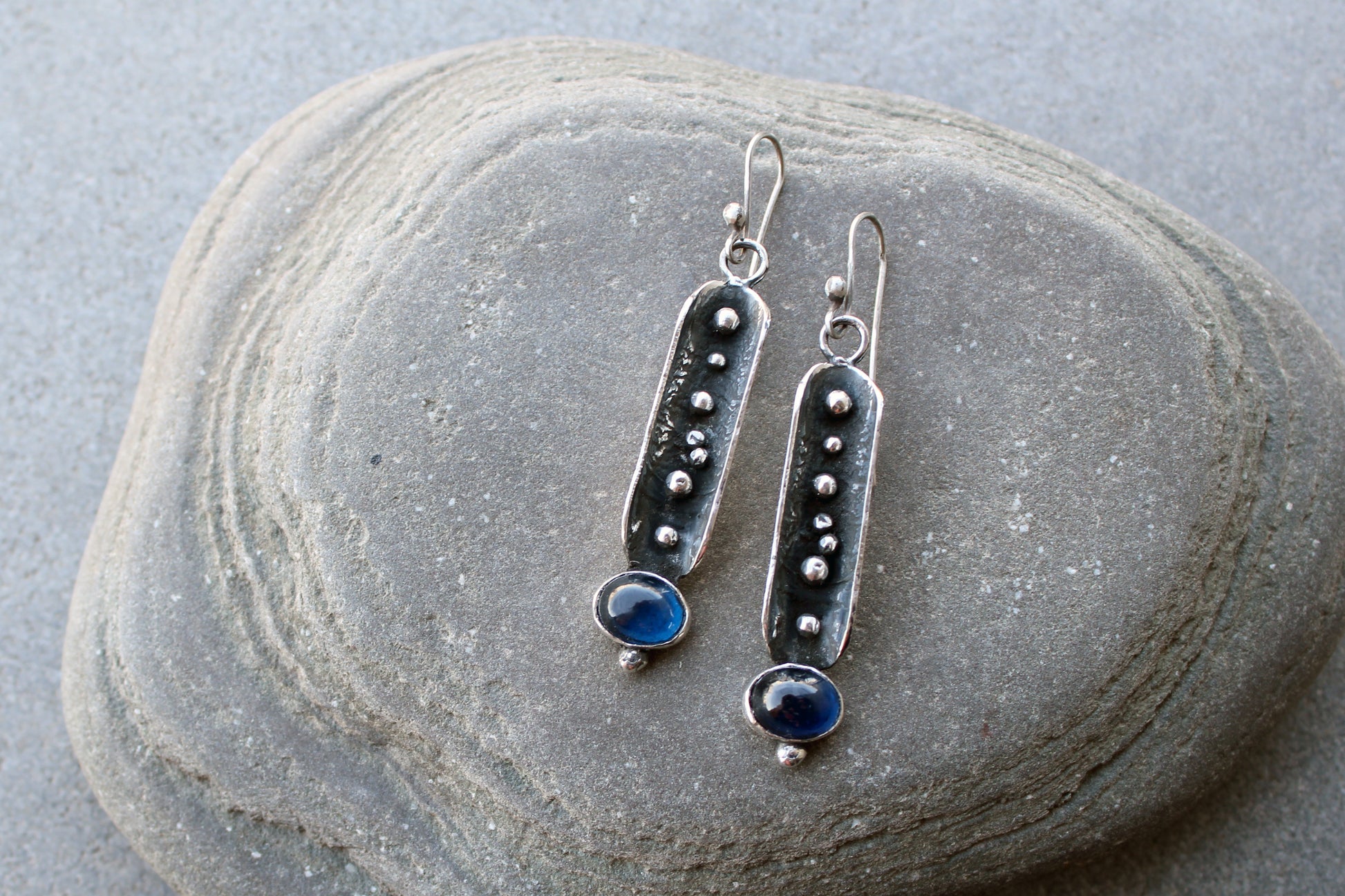 Handcrafted artisan Armenian reticulated sterling silver pod earrings featuring granulated textures and oval lab-grown blue corundum cabochons on classic ear wires