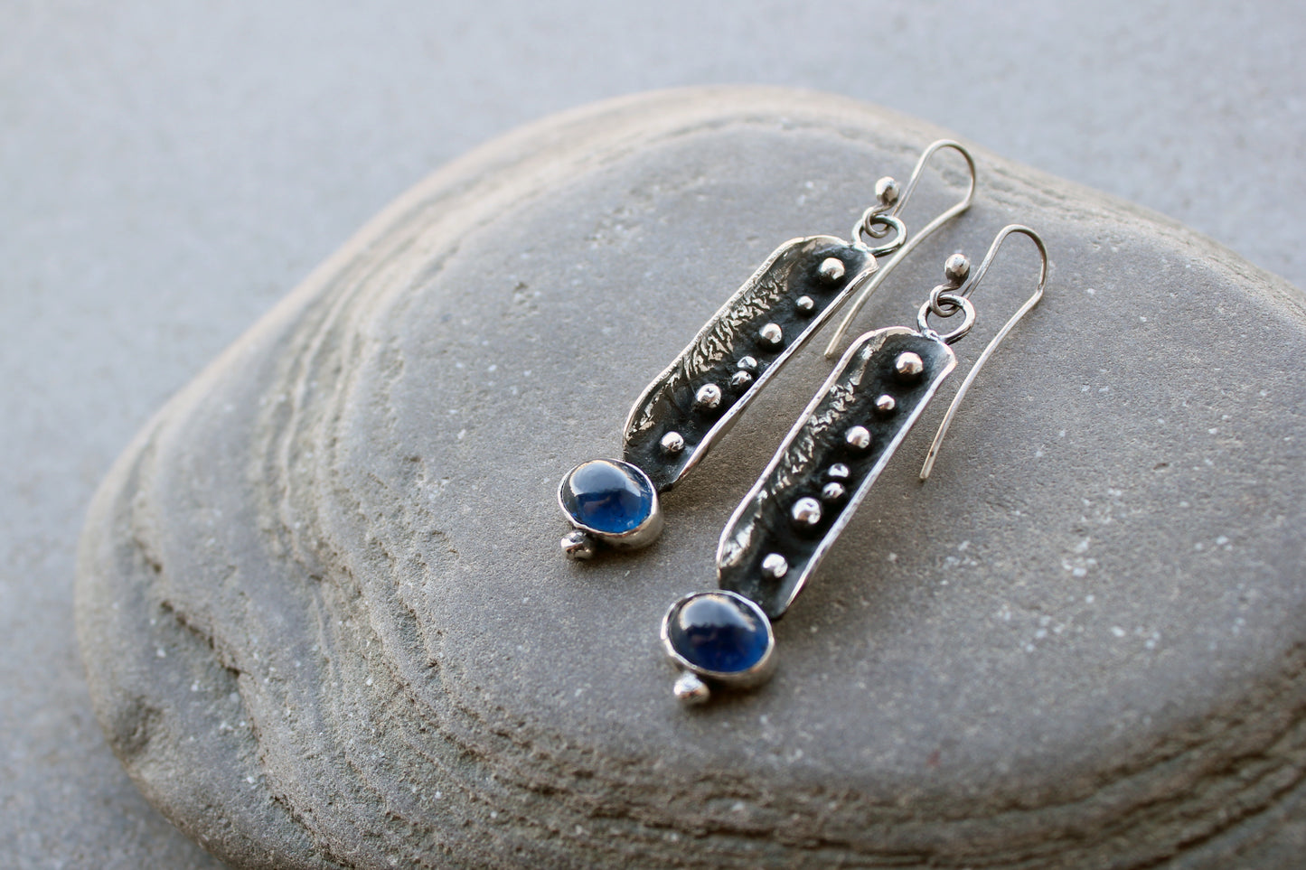 Handcrafted artisan Armenian reticulated sterling silver pod earrings featuring granulated textures and oval lab-grown blue corundum cabochons on classic ear wires
