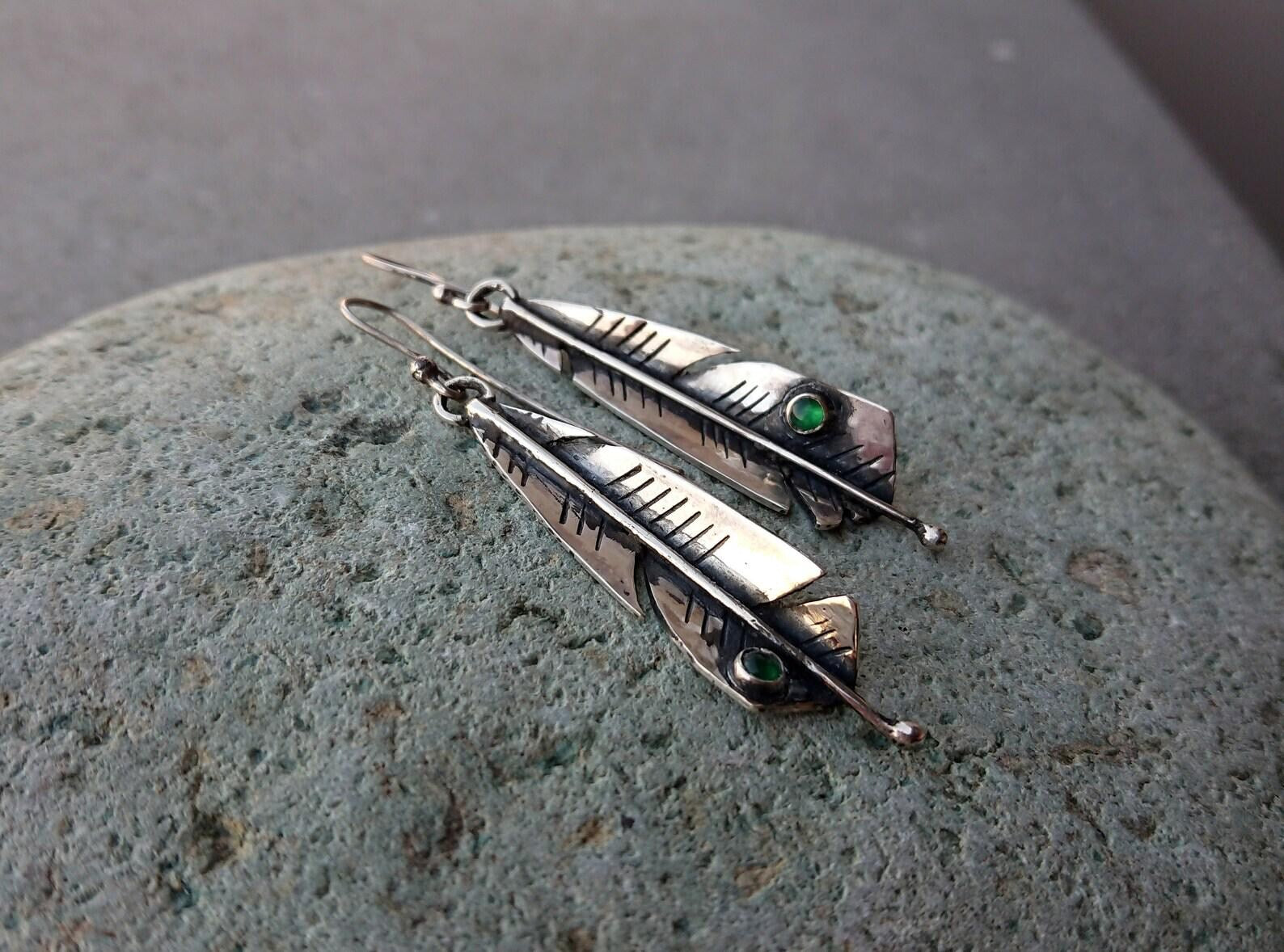 Handcrafted Armenian sterling silver artisan earrings shaped like detailed feathers, each set with small, vibrant round green onyx cabochon near the tip