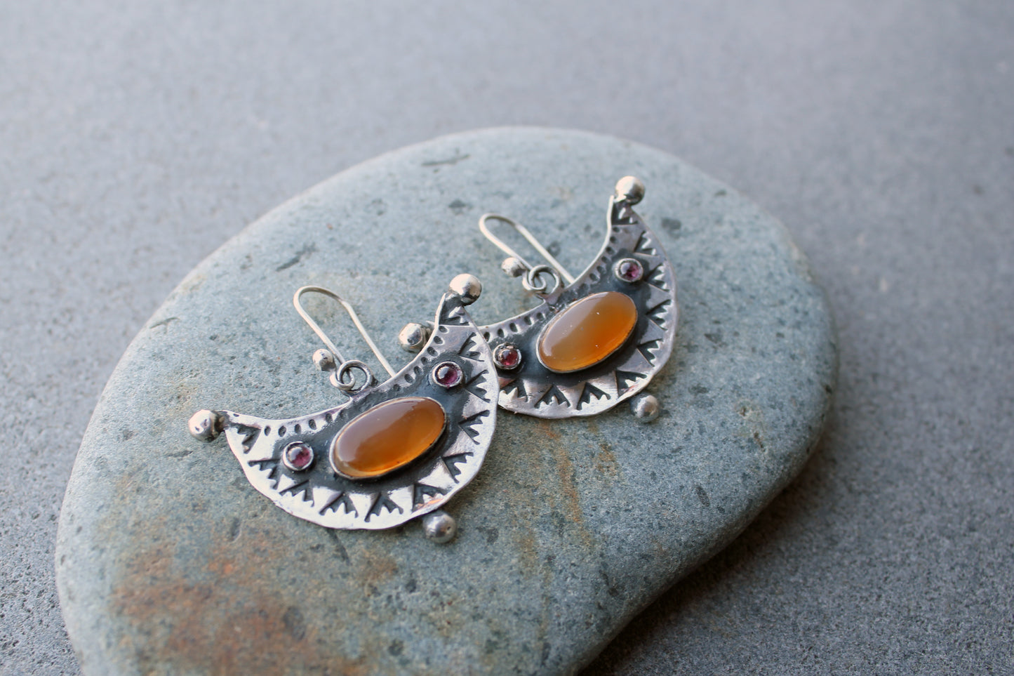 Artisan Armenian handmade silver earrings featuring oval carnelian cabochons and red garnet accents with traditional stamped detailing
