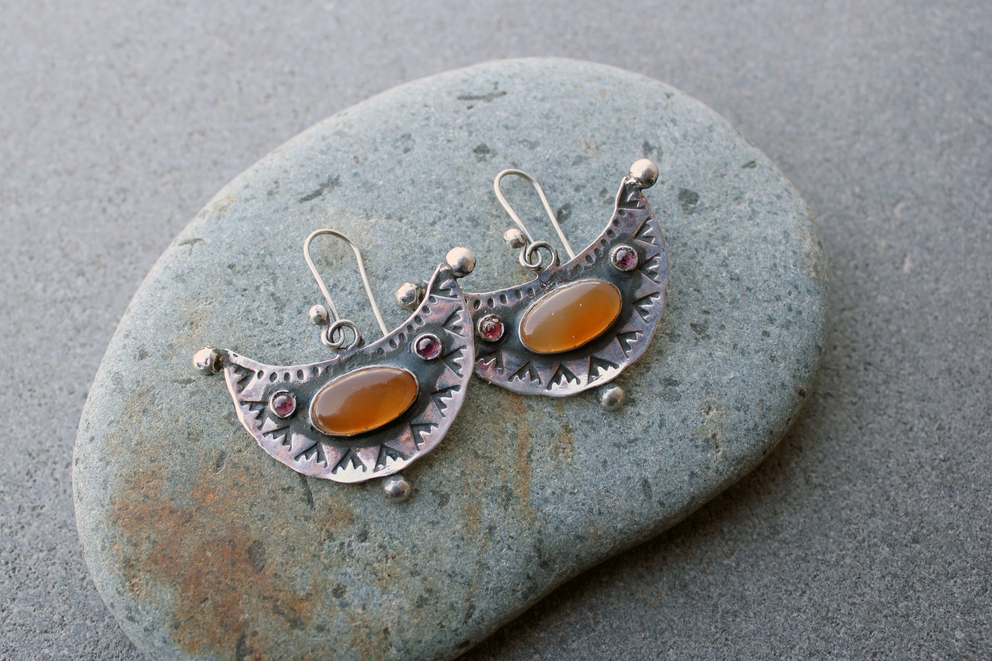 Artisan Armenian handmade silver earrings featuring oval carnelian cabochons and red garnet accents with traditional stamped detailing