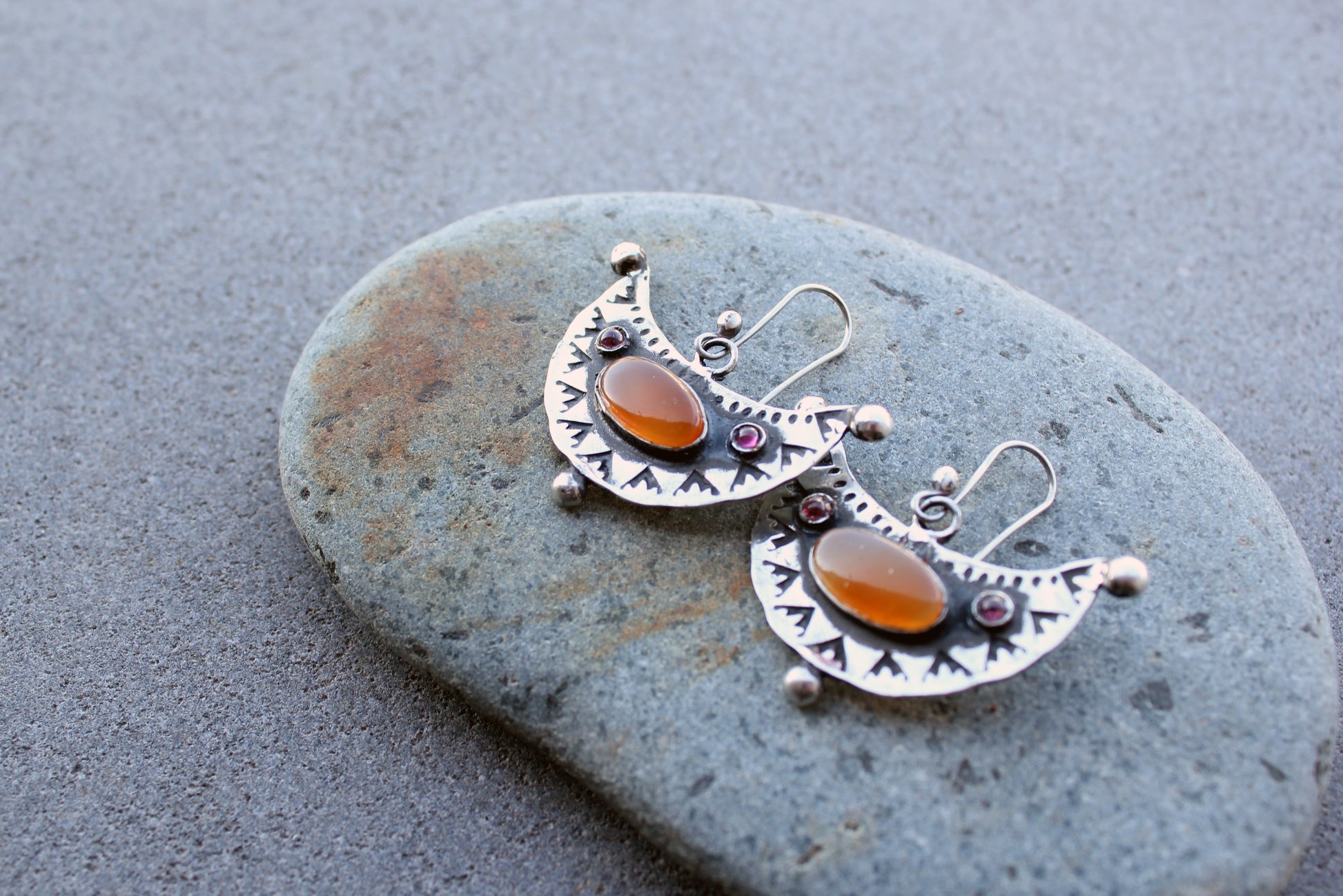 Artisan Armenian handmade silver earrings featuring oval carnelian cabochons and red garnet accents with traditional stamped detailing