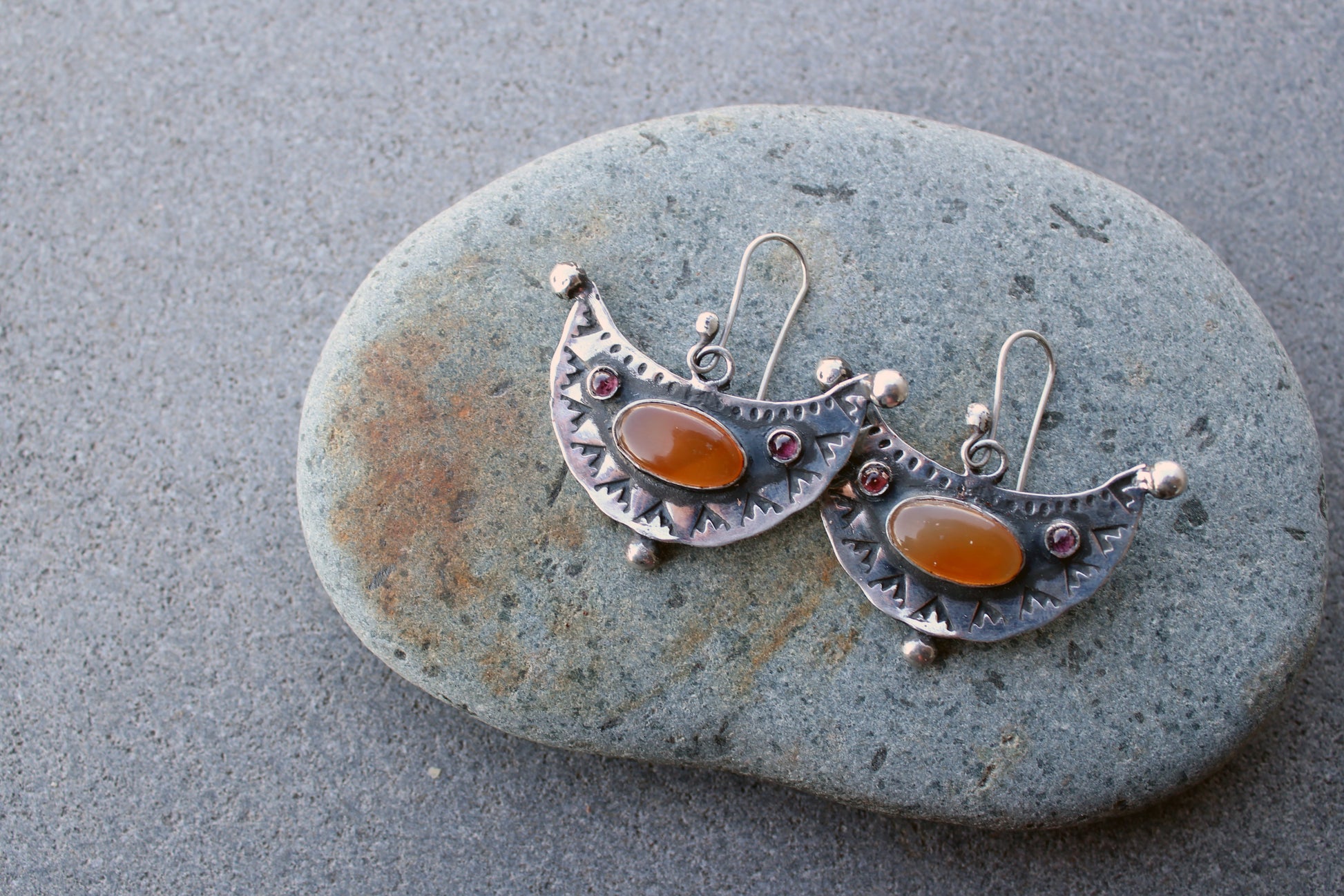 Artisan Armenian handmade silver earrings featuring oval carnelian cabochons and red garnet accents with traditional stamped detailing