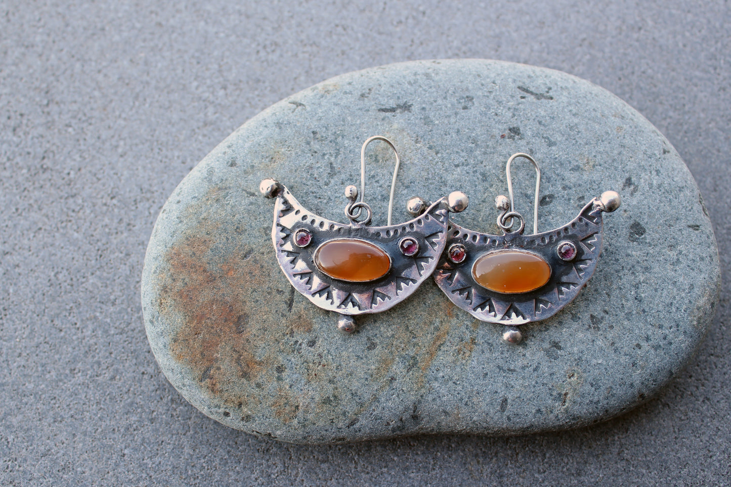 Artisan Armenian handmade silver earrings featuring oval carnelian cabochons and red garnet accents with traditional stamped detailing