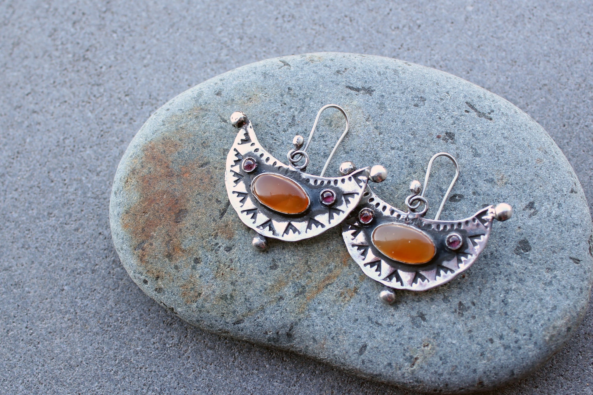 Artisan Armenian handmade silver earrings featuring oval carnelian cabochons and red garnet accents with traditional stamped detailing