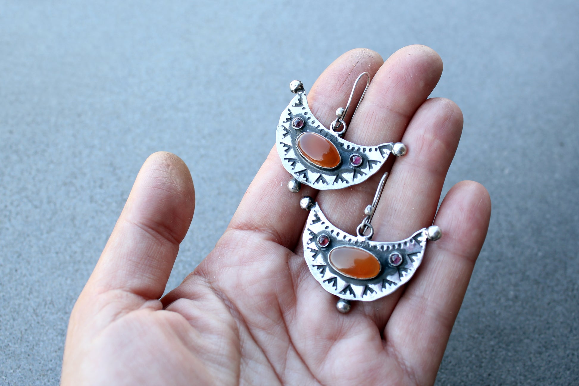 Artisan Armenian handmade silver earrings featuring oval carnelian cabochons and red garnet accents with traditional stamped detailing