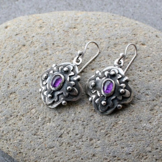 Handcrafted Armenian artisan silversmith sterling silver flower-shaped drop earrings with oval purple corundum centers, featuring oxidized details