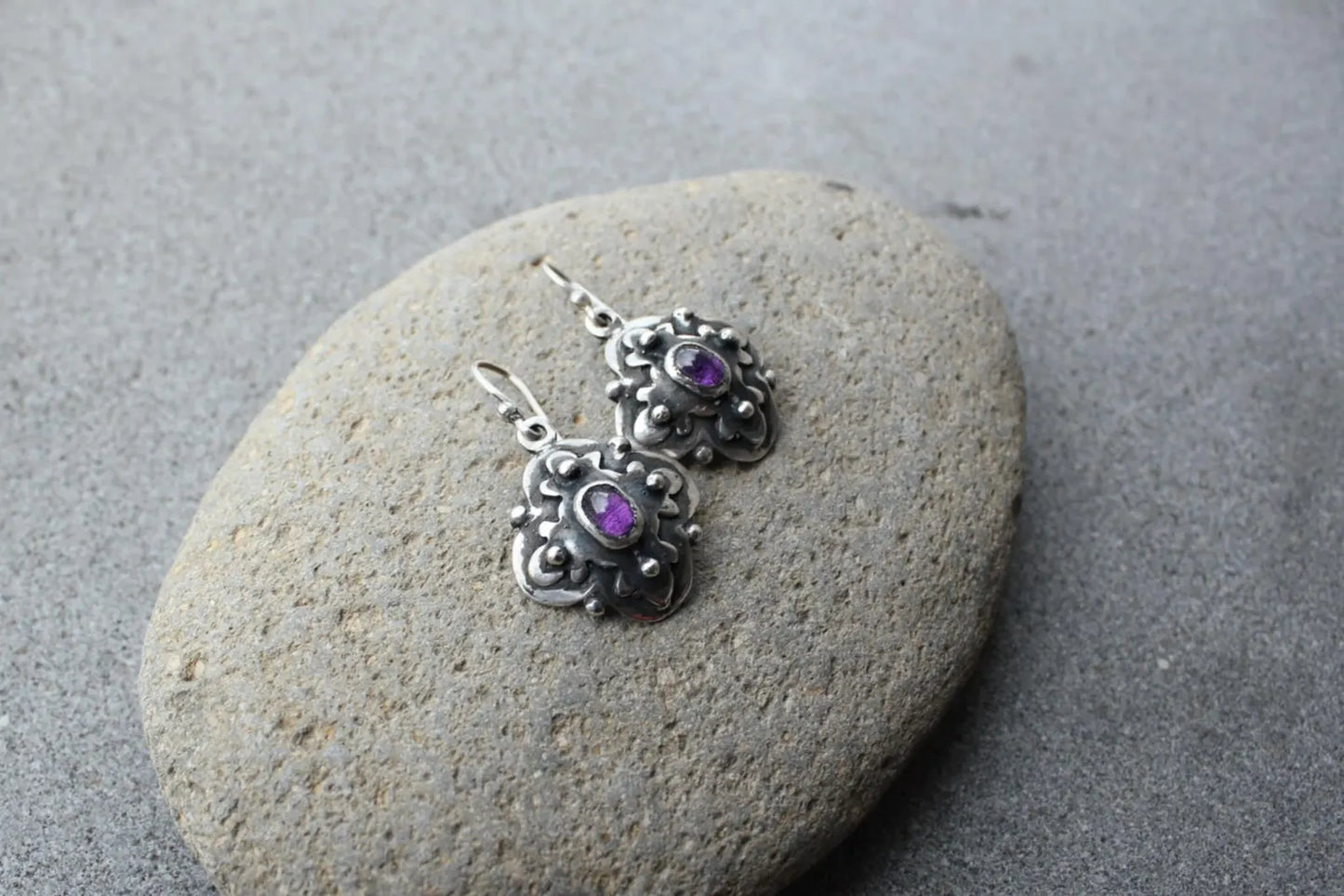 Handcrafted Armenian artisan silversmith sterling silver flower-shaped drop earrings with oval purple corundum centers, featuring oxidized details