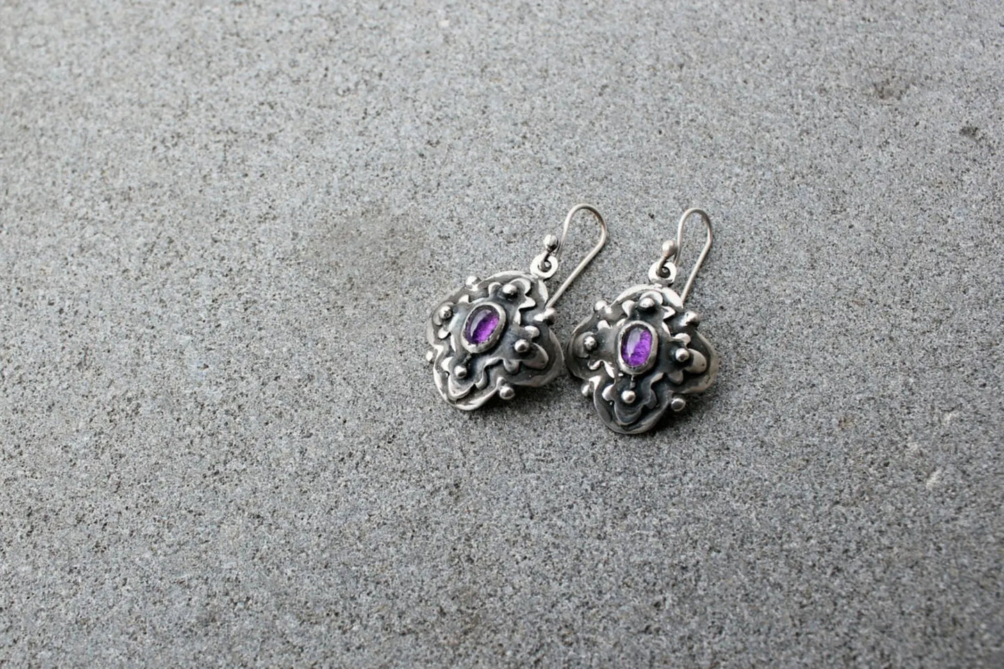 Handcrafted Armenian artisan silversmith sterling silver flower-shaped drop earrings with oval purple corundum centers, featuring oxidized details