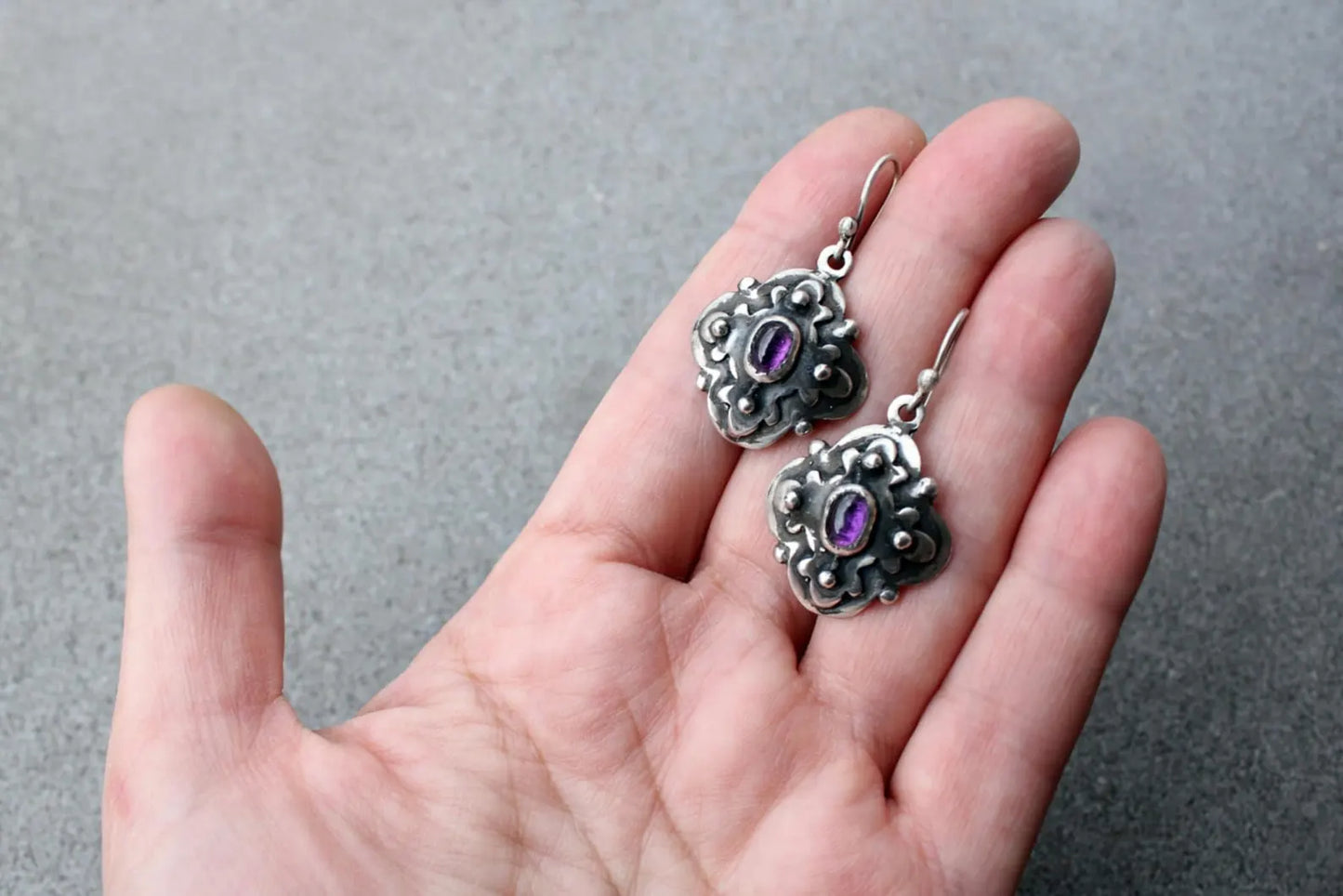 Handcrafted Armenian artisan silversmith sterling silver flower-shaped drop earrings with oval purple corundum centers, featuring oxidized details