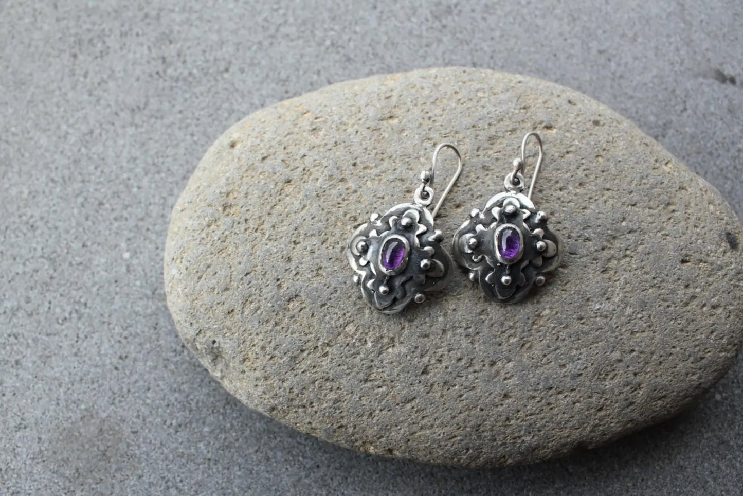 Handcrafted Armenian artisan silversmith sterling silver flower-shaped drop earrings with oval purple corundum centers, featuring oxidized details