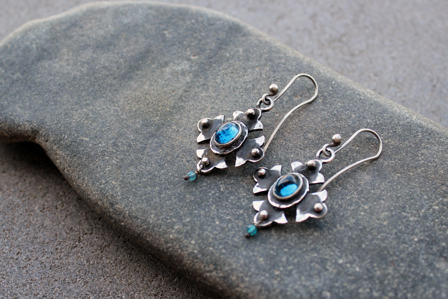 Armenian artisan vintage style sterling silver silversmith earrings featuring oval blue corundum gemstones set in a decorative floral frame