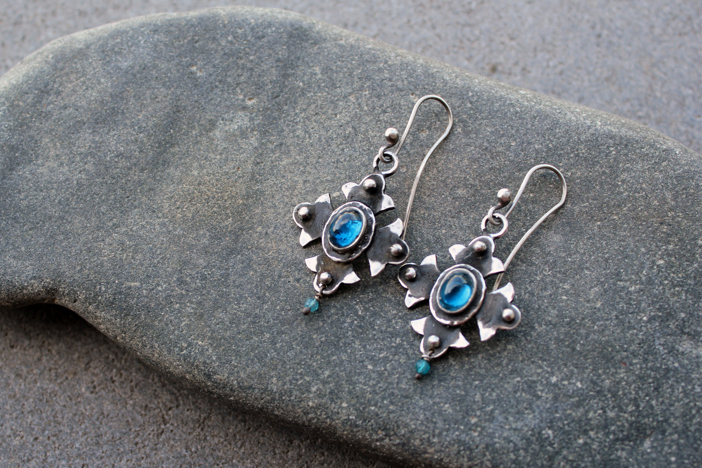 Armenian artisan vintage style sterling silver silversmith earrings featuring oval blue corundum gemstones set in a decorative floral frame
