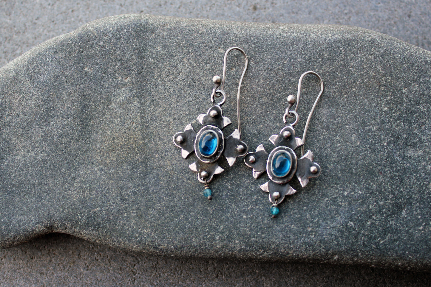Armenian artisan vintage style sterling silver silversmith earrings featuring oval blue corundum gemstones set in a decorative floral frame