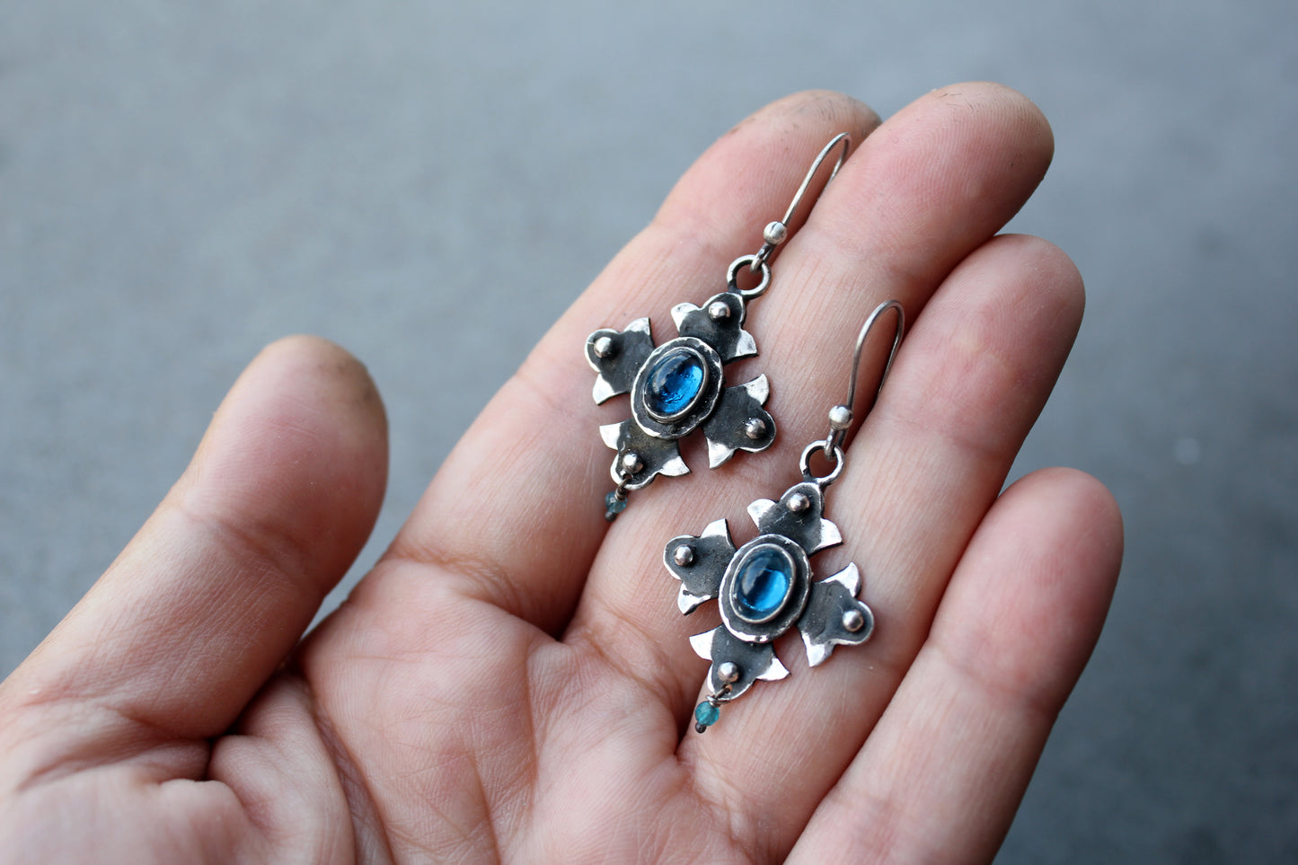 Armenian artisan vintage style sterling silver silversmith earrings featuring oval blue corundum gemstones set in a decorative floral frame