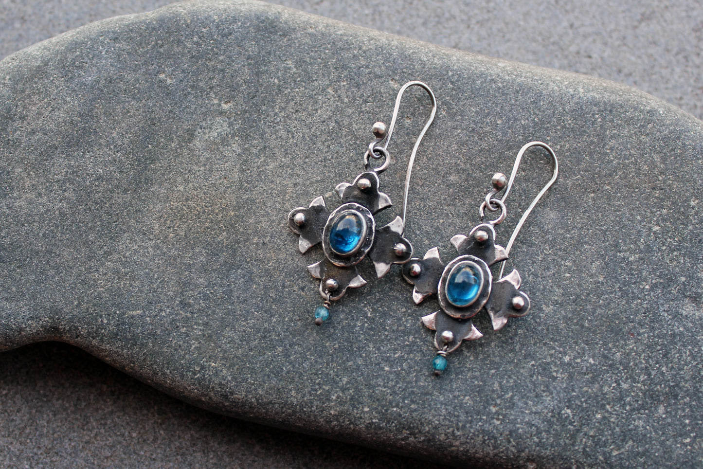 Armenian artisan vintage style sterling silver silversmith earrings featuring oval blue corundum gemstones set in a decorative floral frame
