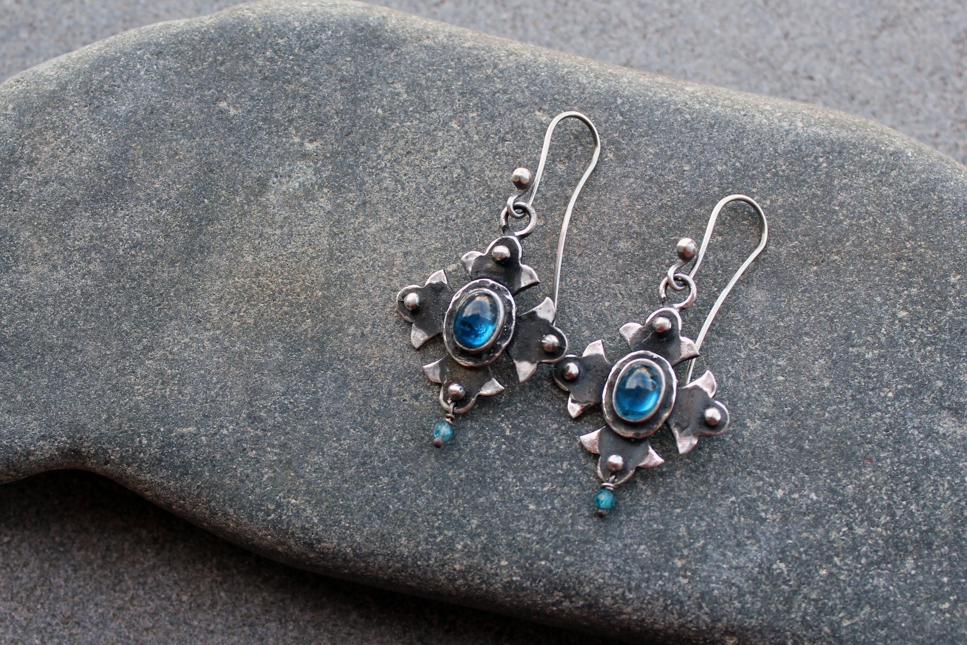 Armenian artisan vintage style sterling silver silversmith earrings featuring oval blue corundum gemstones set in a decorative floral frame
