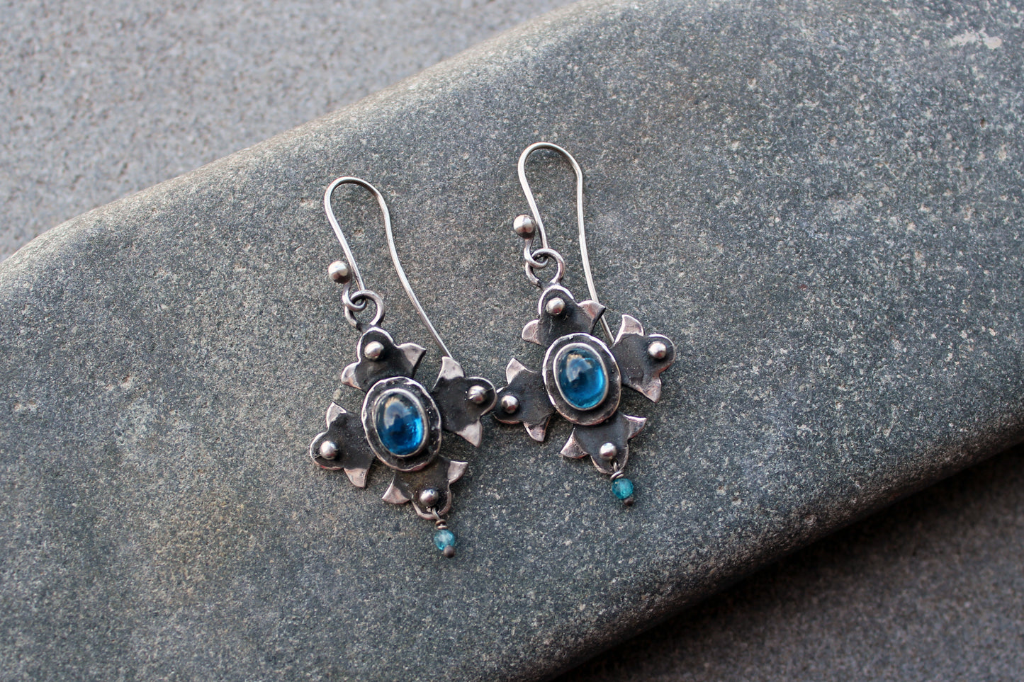Armenian artisan vintage style sterling silver silversmith earrings featuring oval blue corundum gemstones set in a decorative floral frame