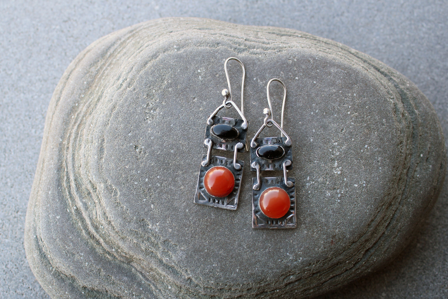 Handcrafted artisan drop earrings featuring oval black onyx and round carnelian  cabochons, set in oxidized sterling silver with tribal-style geometric engravings