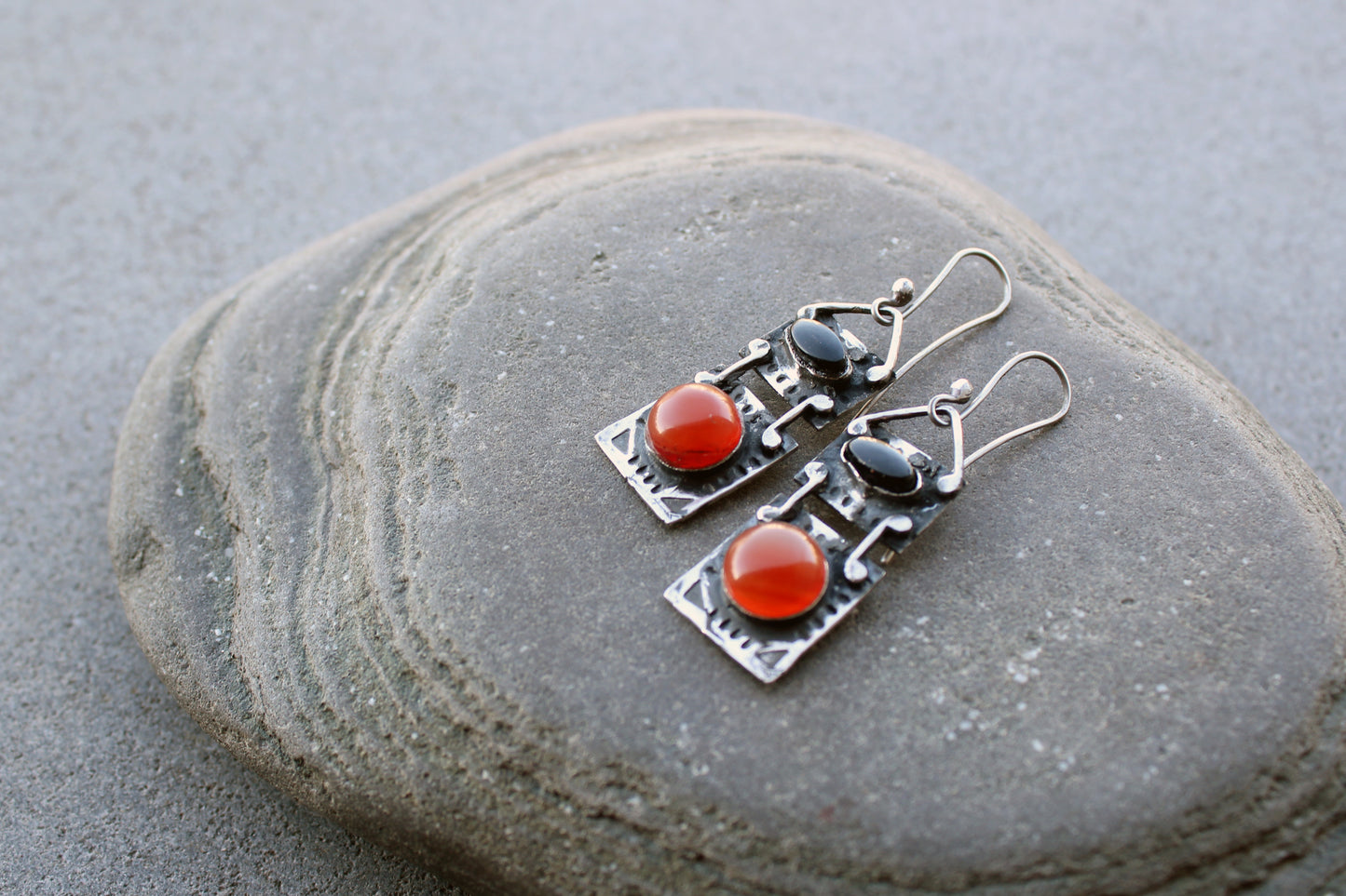 Handcrafted artisan drop earrings featuring oval black onyx and round carnelian  cabochons, set in oxidized sterling silver with tribal-style geometric engravings