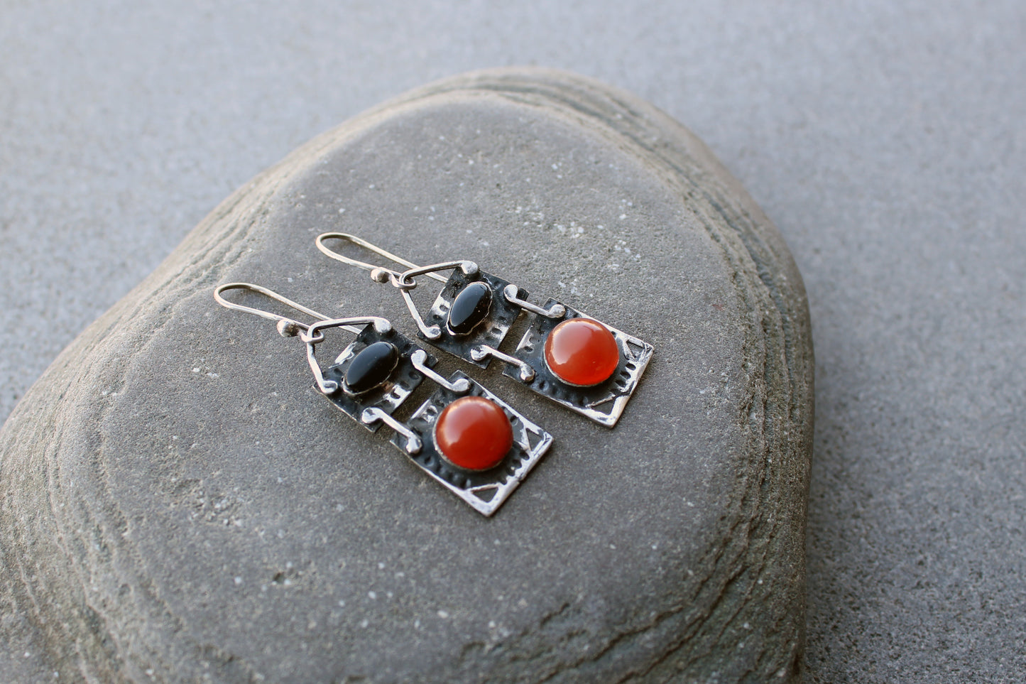 Handcrafted artisan drop earrings featuring oval black onyx and round carnelian  cabochons, set in oxidized sterling silver with tribal-style geometric engravings