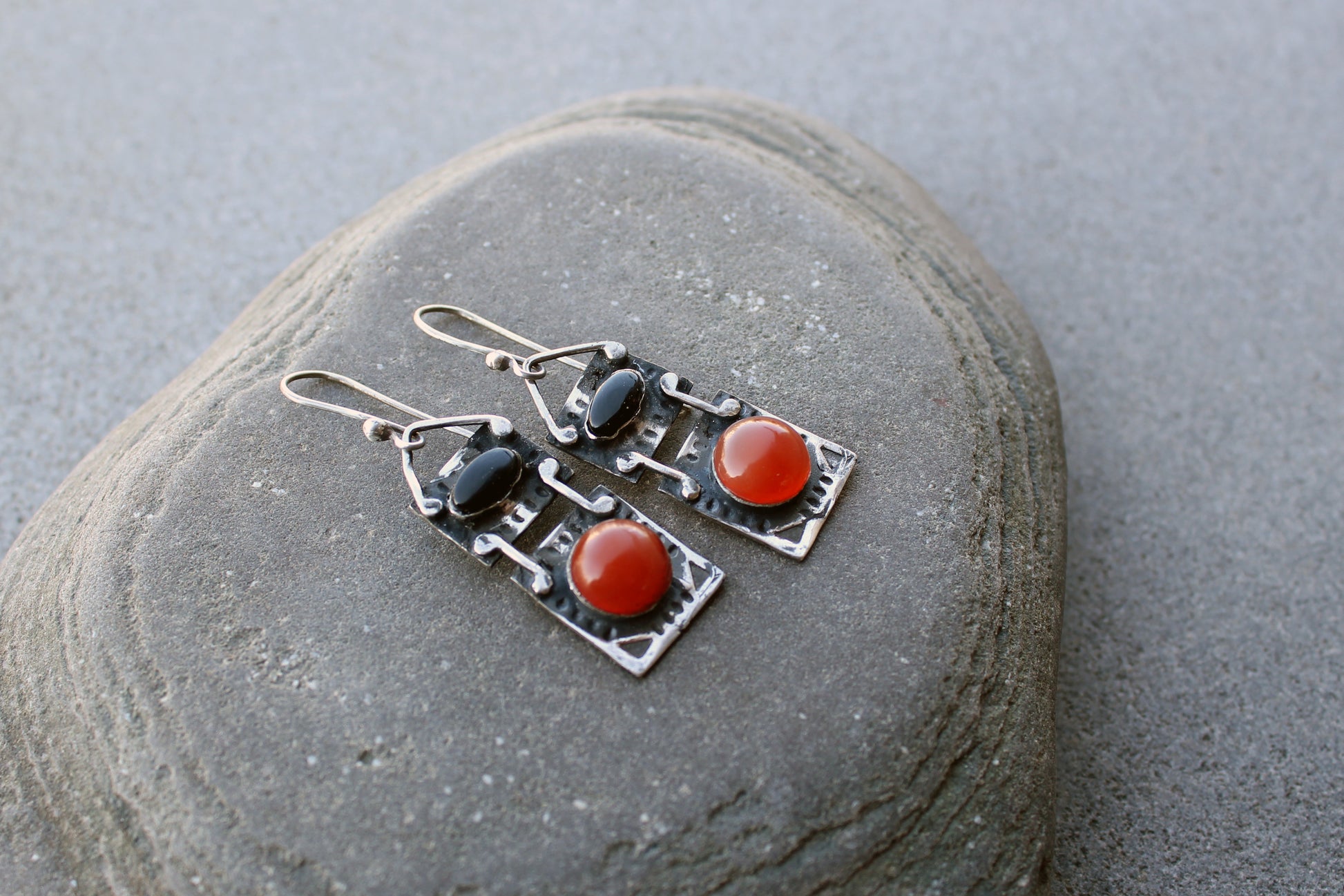 Handcrafted artisan drop earrings featuring oval black onyx and round carnelian  cabochons, set in oxidized sterling silver with tribal-style geometric engravings