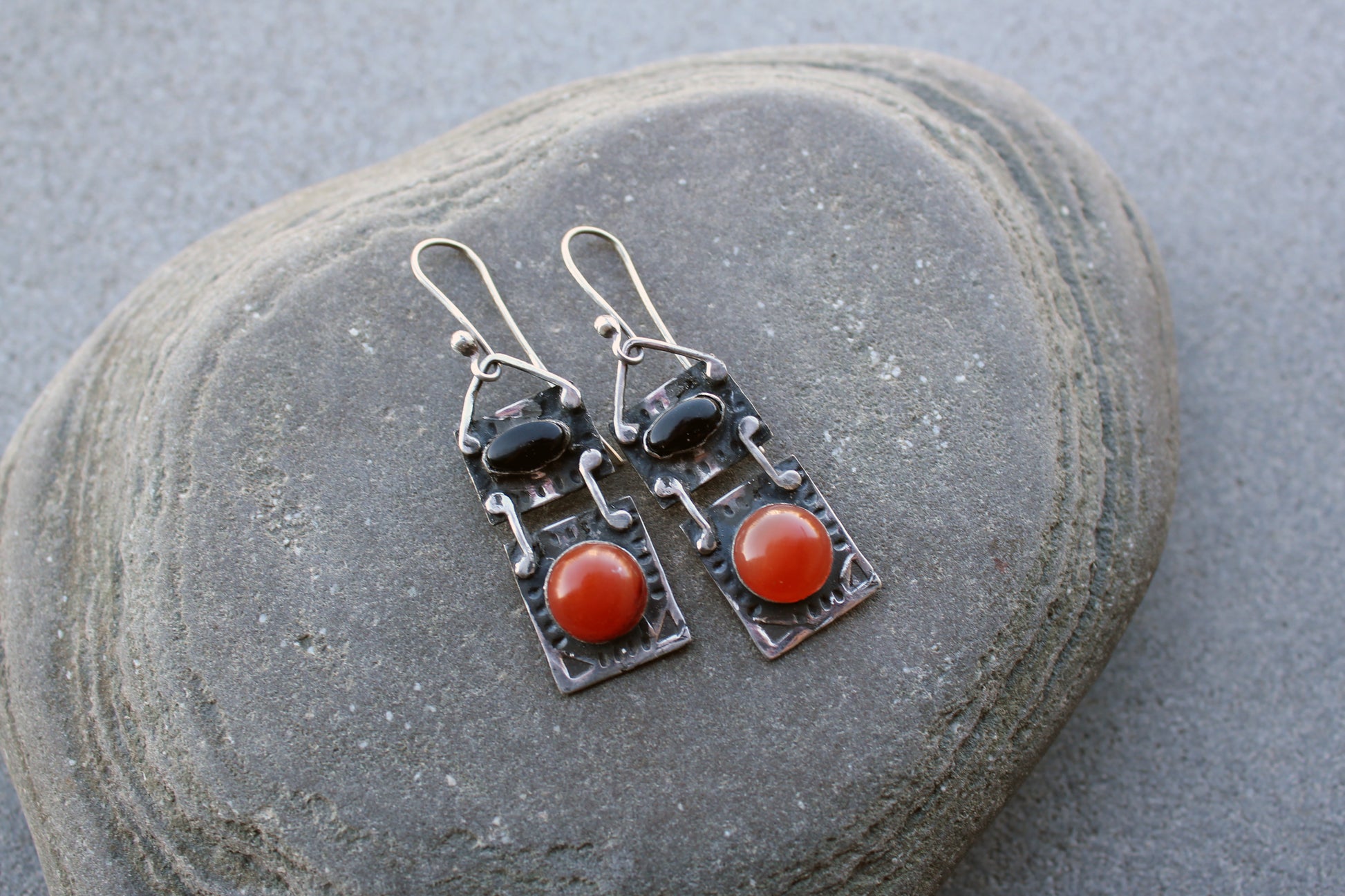 Handcrafted artisan drop earrings featuring oval black onyx and round carnelian  cabochons, set in oxidized sterling silver with tribal-style geometric engravings