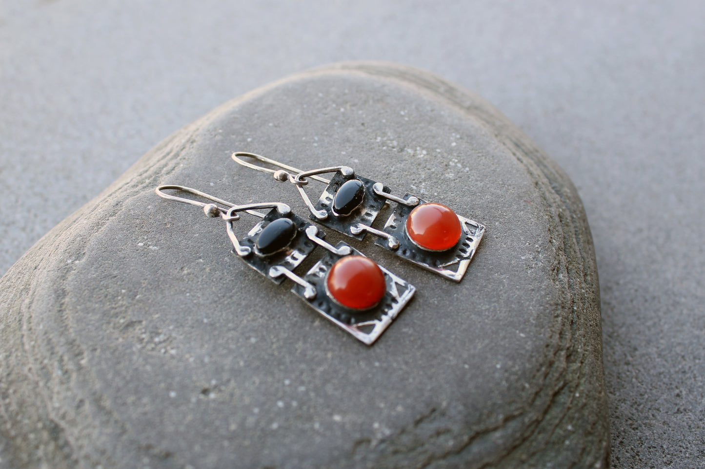 Handcrafted artisan drop earrings featuring oval black onyx and round carnelian  cabochons, set in oxidized sterling silver with tribal-style geometric engravings