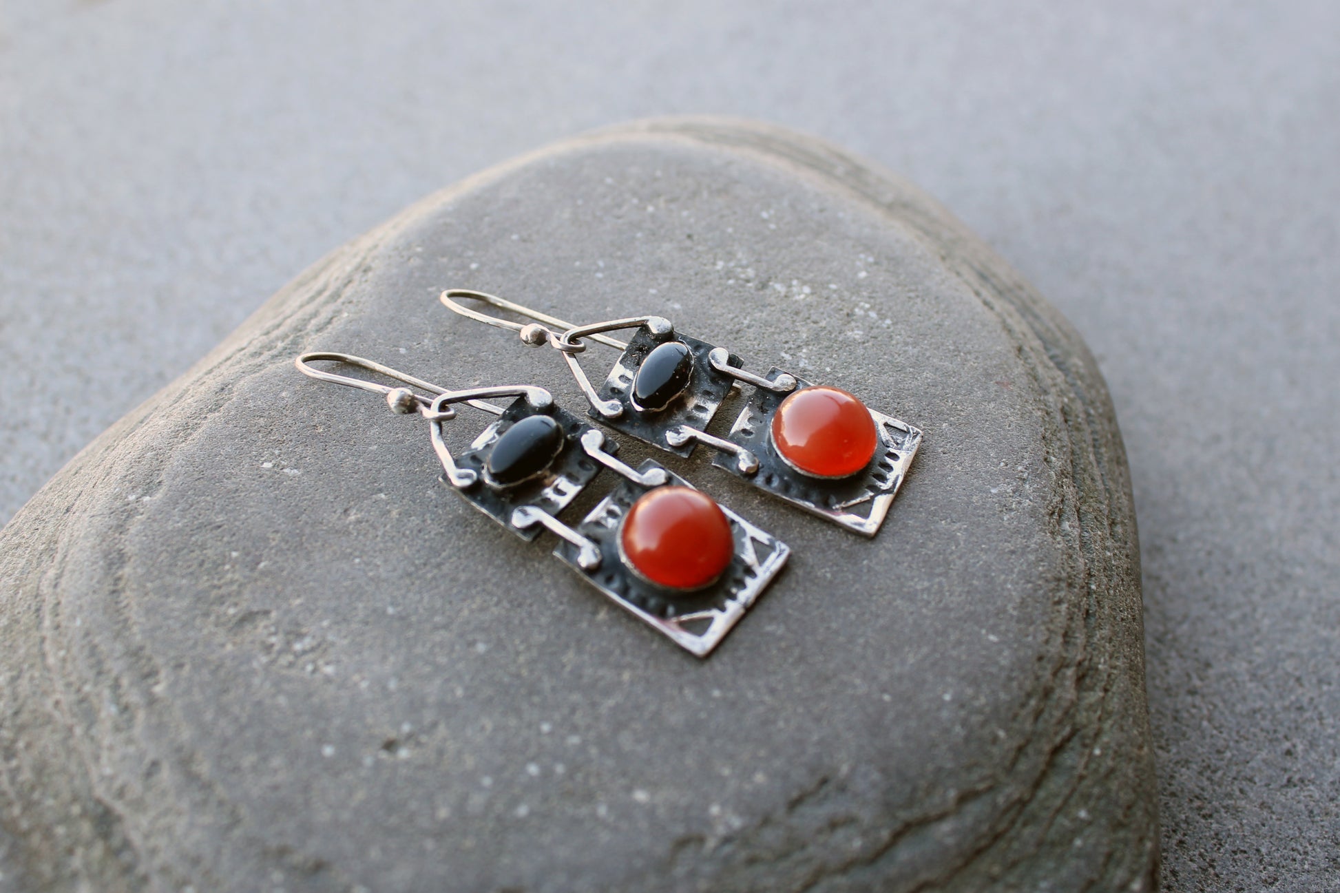 Handcrafted artisan drop earrings featuring oval black onyx and round carnelian  cabochons, set in oxidized sterling silver with tribal-style geometric engravings