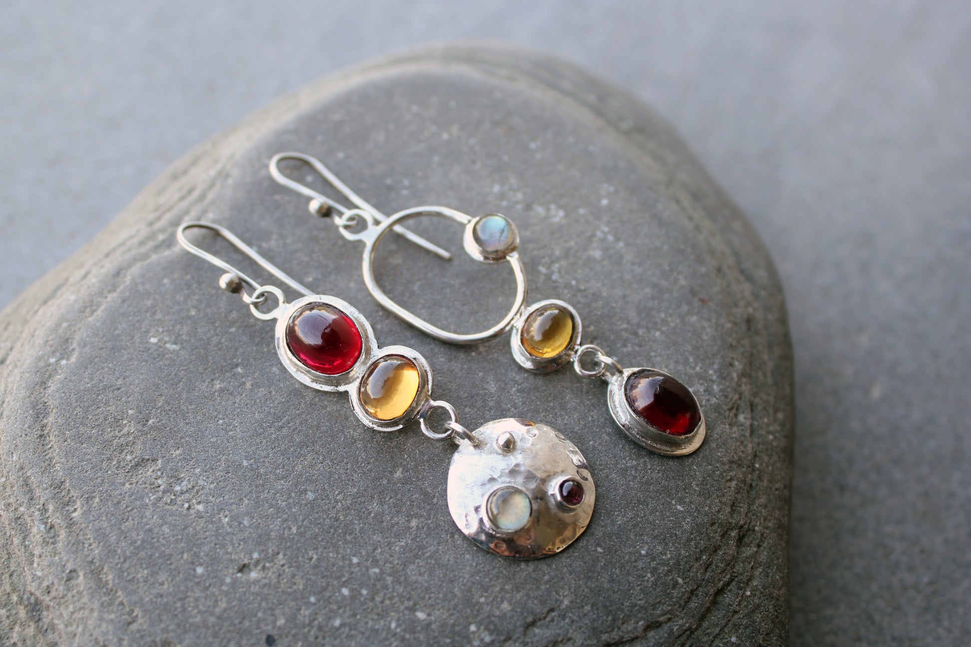 Mismatched sterling silver Armenian artisan handmade drop earrings, featuring oval red and orange corundums and labradorite stones