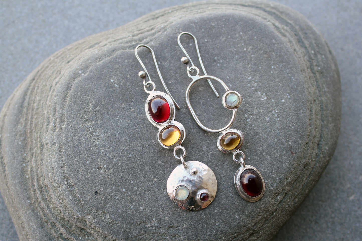 Mismatched sterling silver Armenian artisan handmade drop earrings, featuring oval red and orange corundums and labradorite stones