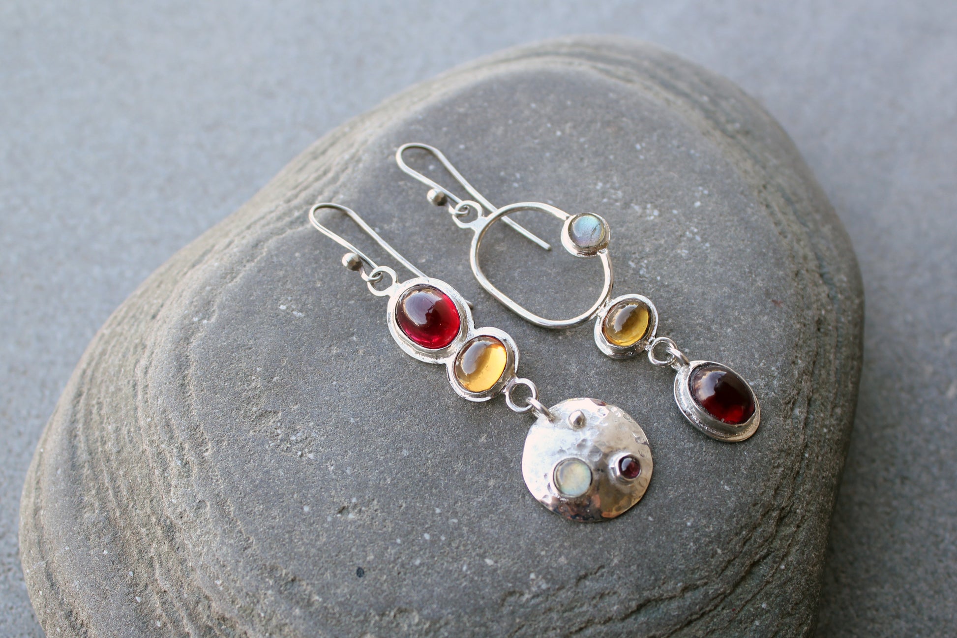 Mismatched sterling silver Armenian artisan handmade drop earrings, featuring oval red and orange corundums and labradorite stones