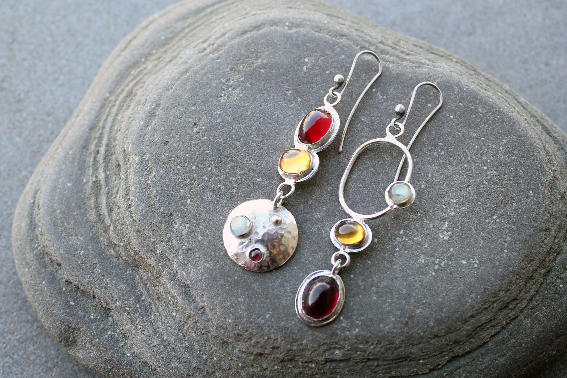 Mismatched sterling silver Armenian artisan handmade drop earrings, featuring oval red and orange corundums and labradorite stones