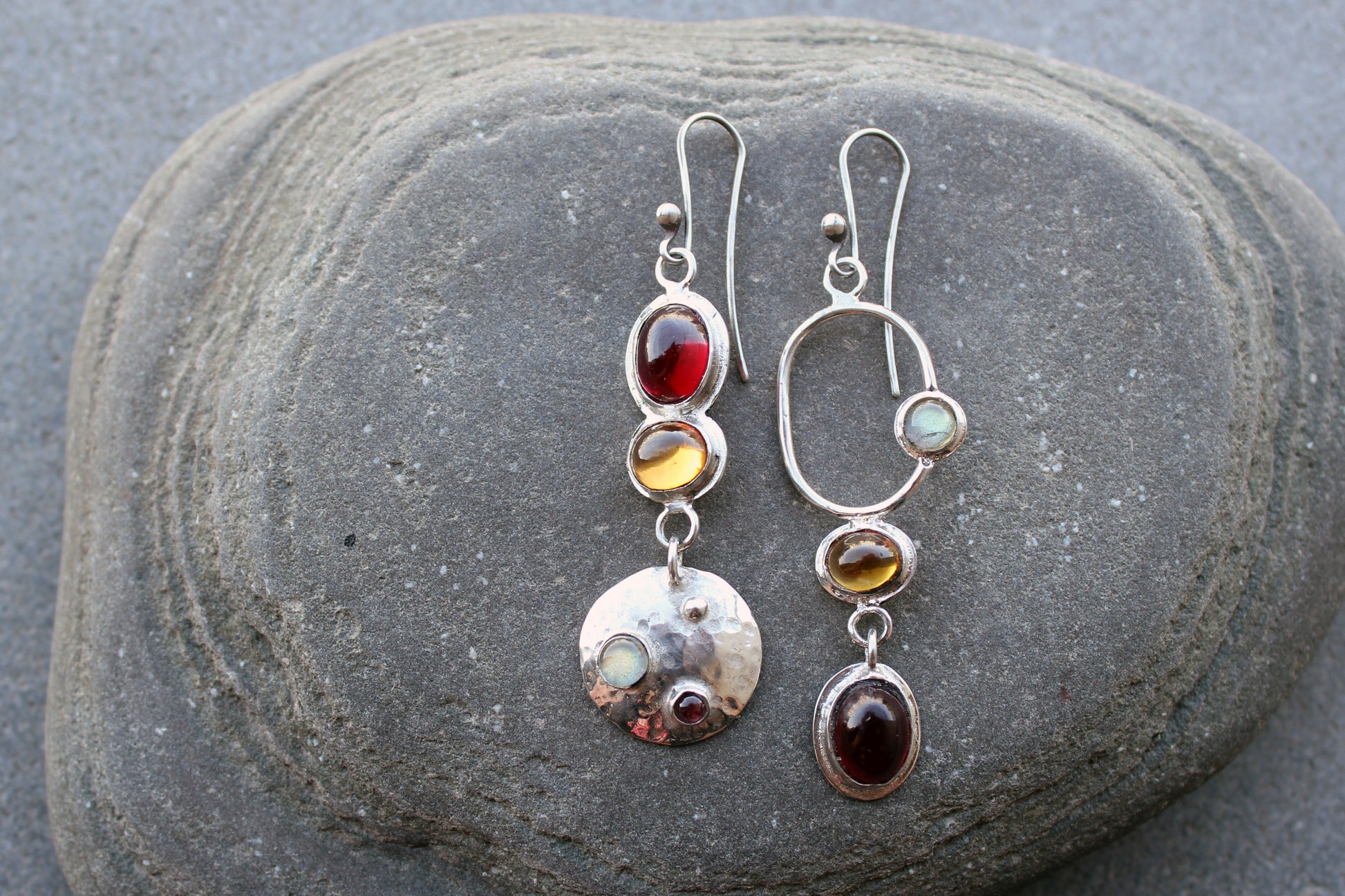 Mismatched sterling silver Armenian artisan handmade drop earrings, featuring oval red and orange corundums and labradorite stones