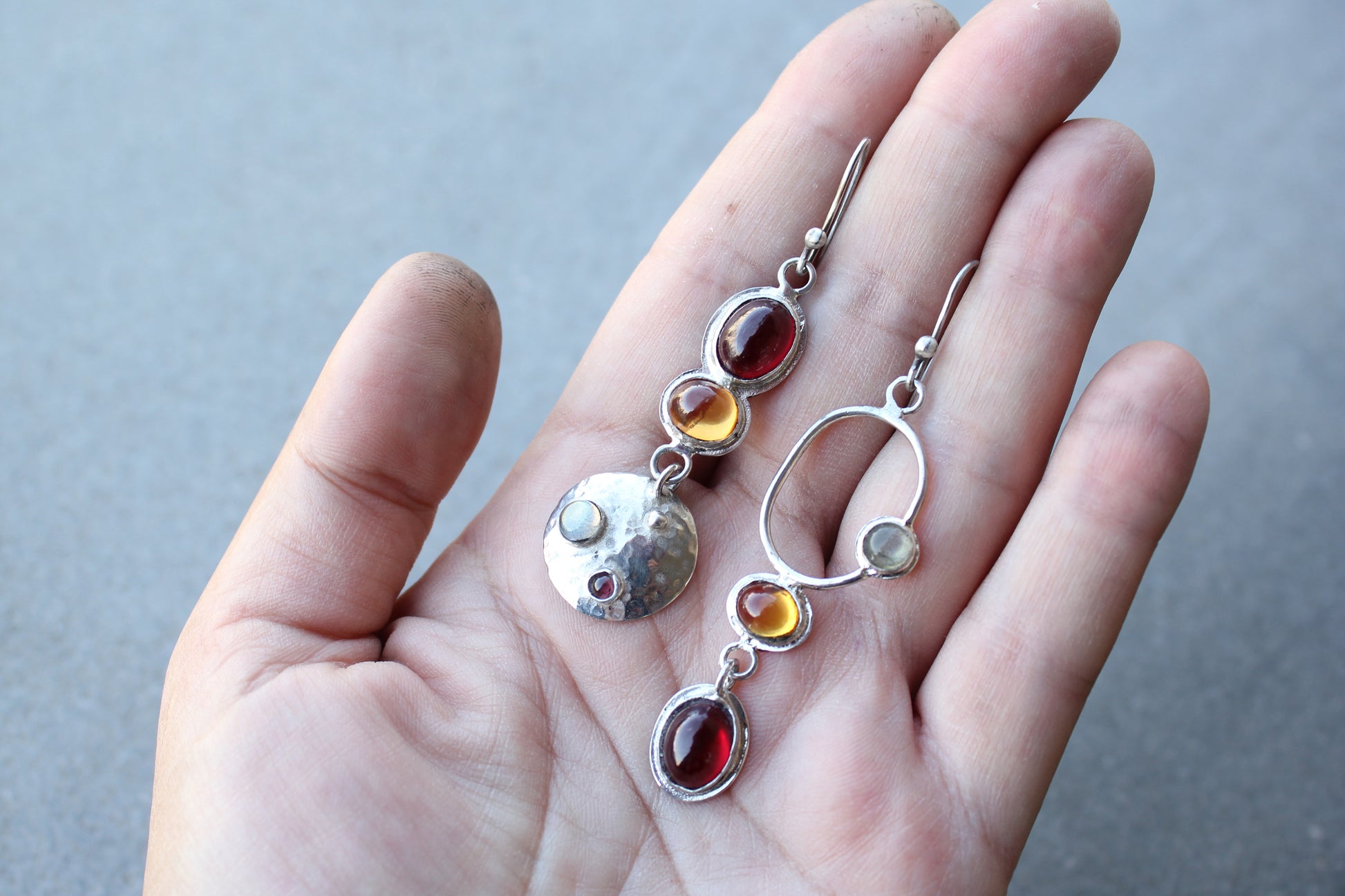 Mismatched sterling silver Armenian artisan handmade drop earrings, featuring oval red and orange corundums and labradorite stones