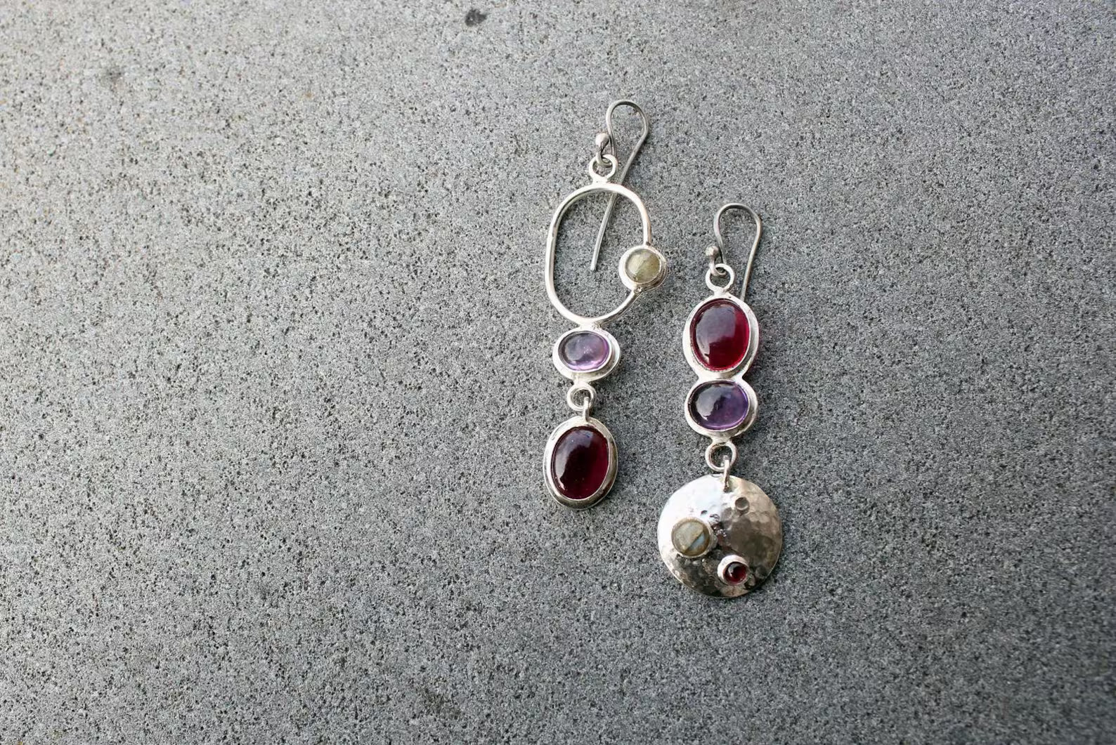 Mismatched sterling silver silversmith Armenian artisan handmade drop earrings, featuring oval red and purple corundums and labradorite stones